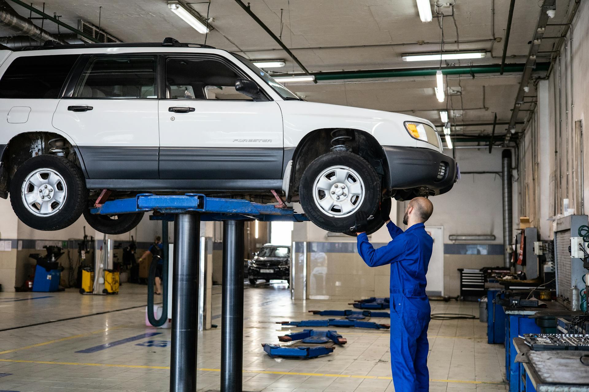 Subaru Forester on a mechanic lift at a car repair garage