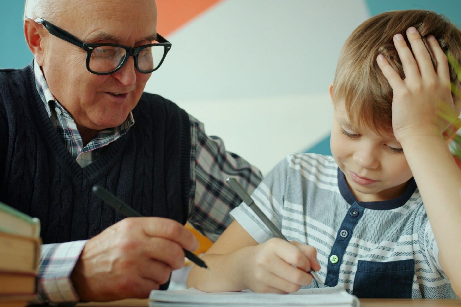 A tutor teaching a young boy.