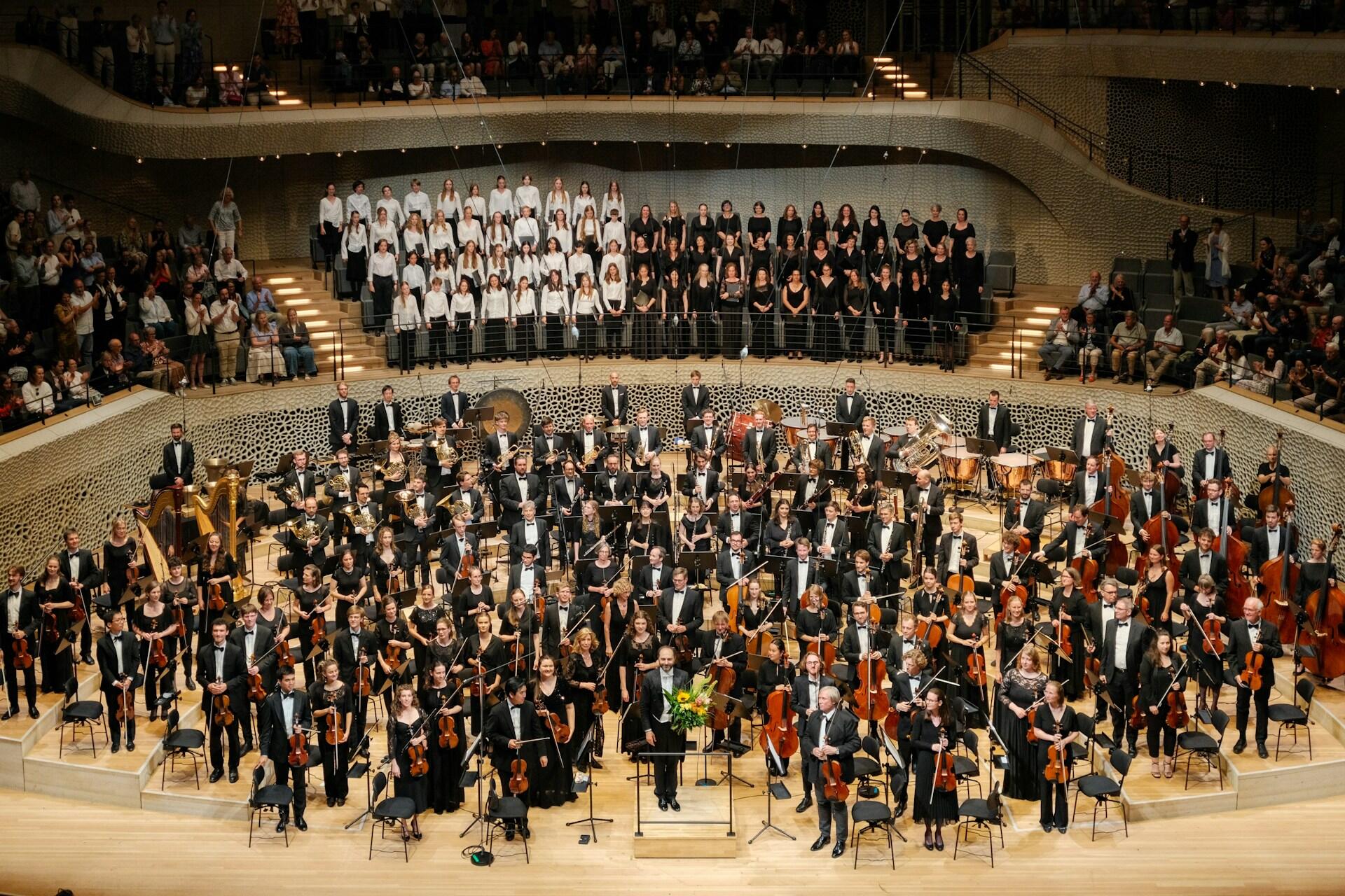 high school concert with choir, band, and orchestra on stage