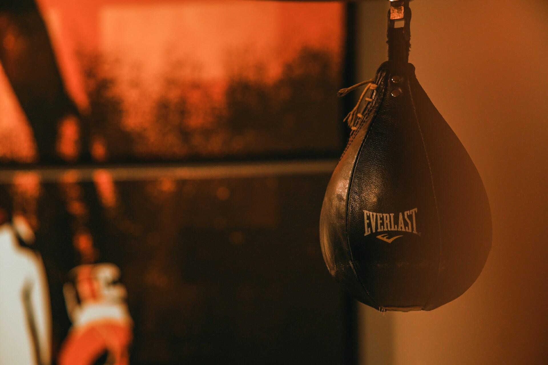A boxing punching bag in a dark room.
