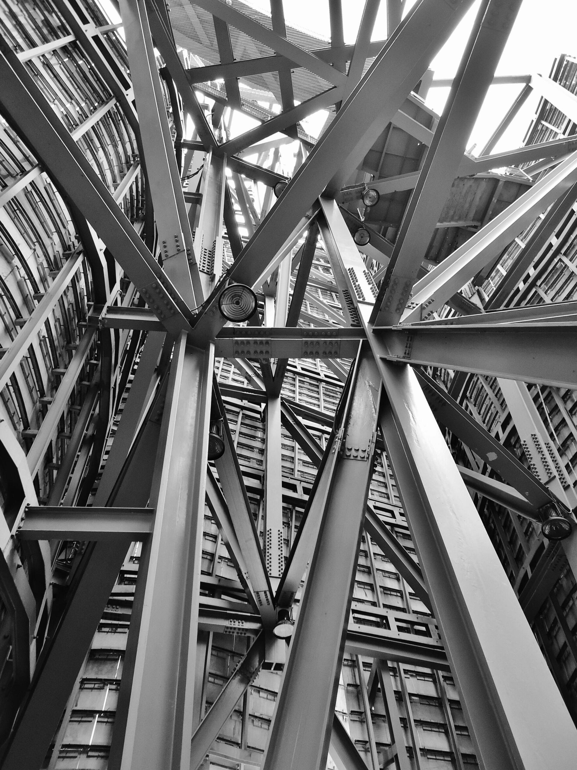 Close-up view of a building’s architectural structure, featuring intersecting steel beams that form a strong, geometric framework. Source: Pixabay.