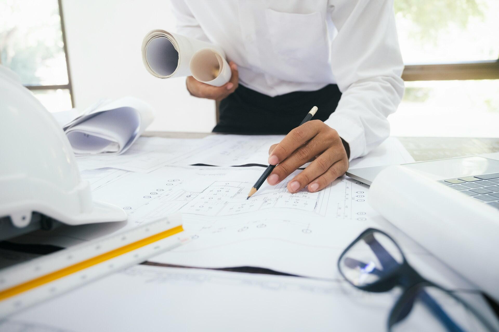 person sitting at a desk with drawings and a notebook
