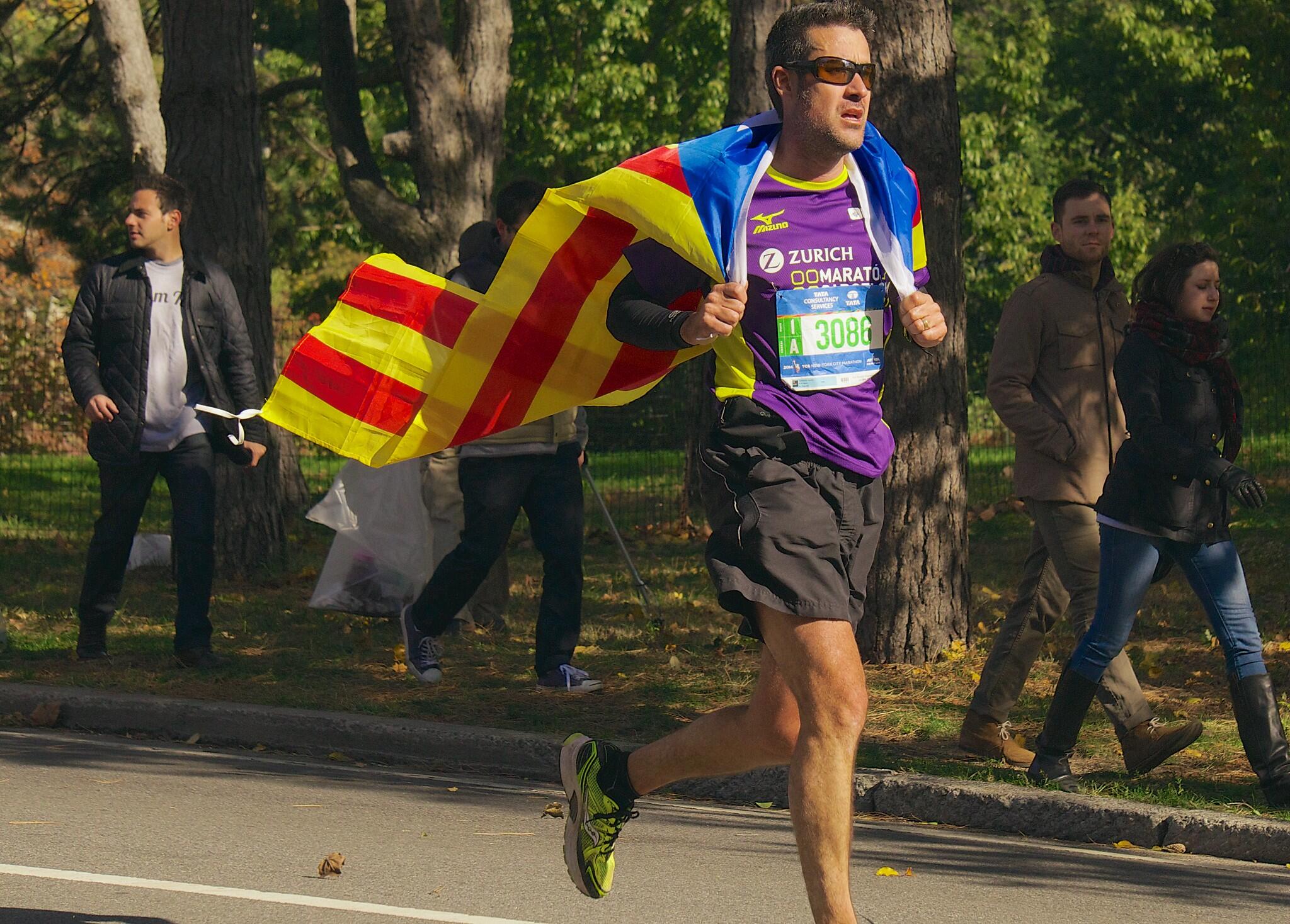 a marathon runner with a charity shirt and flag cape