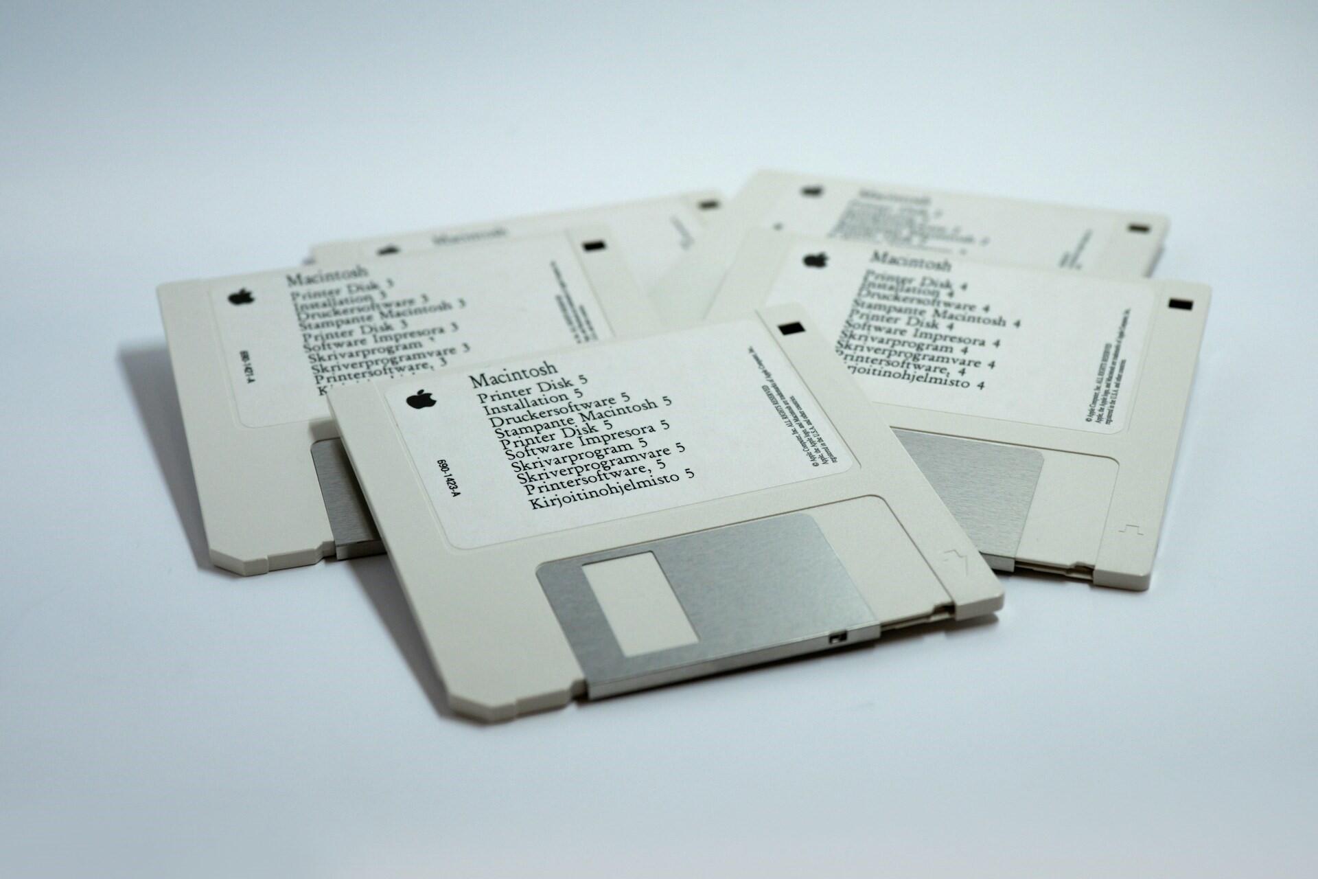 Several white floppy disks stacked and overlapping on a white surface.