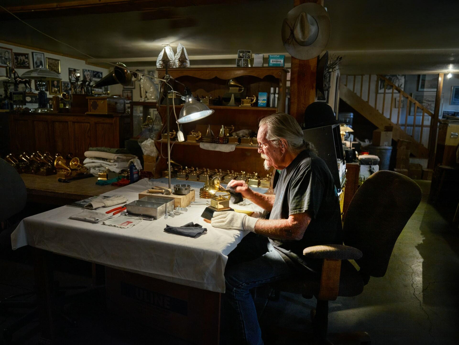 man working in a workshop surrounded by tools to make the grammy awards