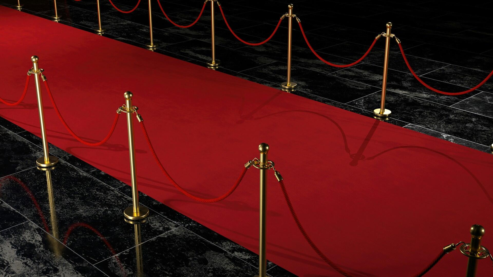 A red carpet lined with golden stauncheons and velvet ropes. 