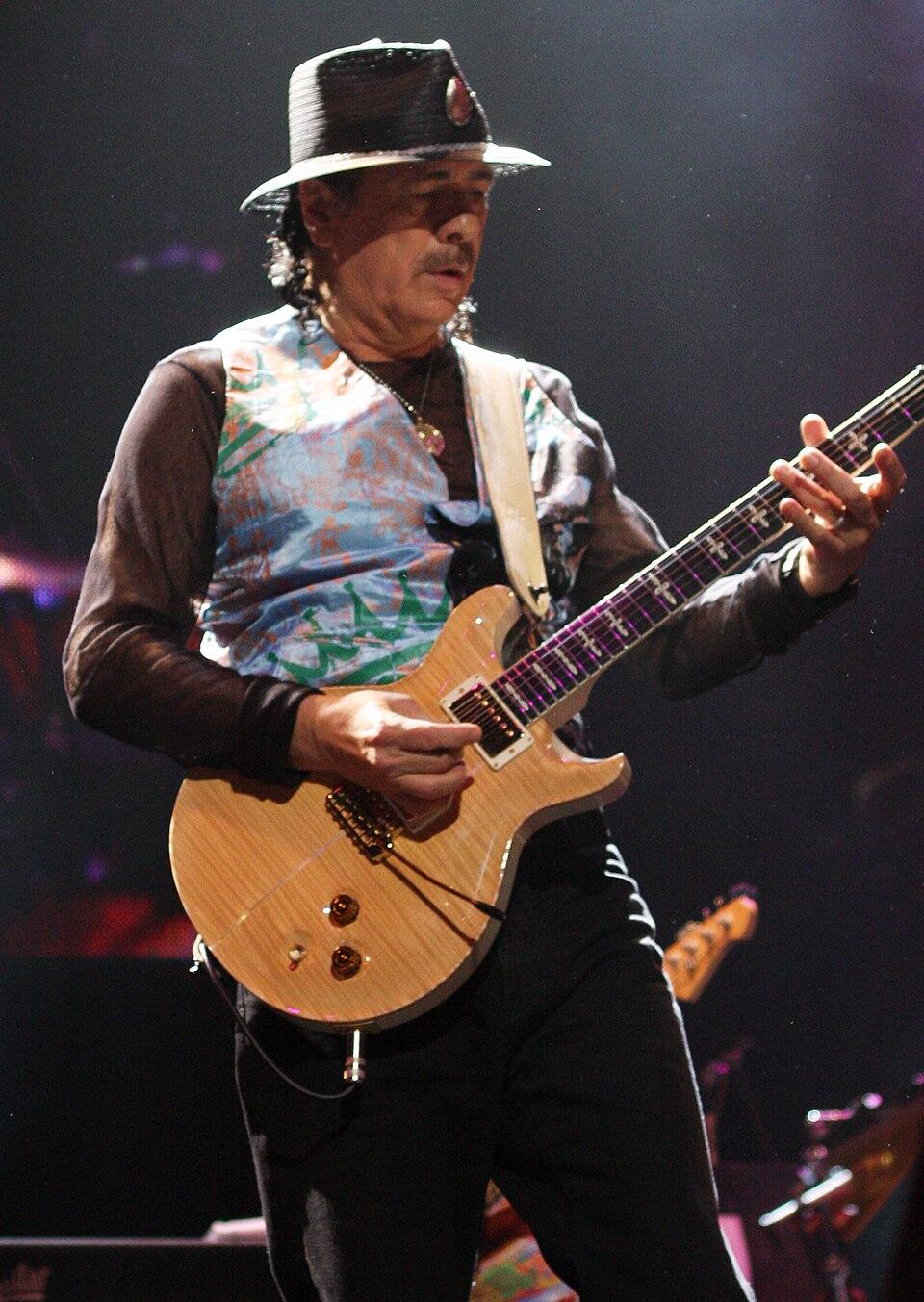 carlos santana performing onstage with a guitar
