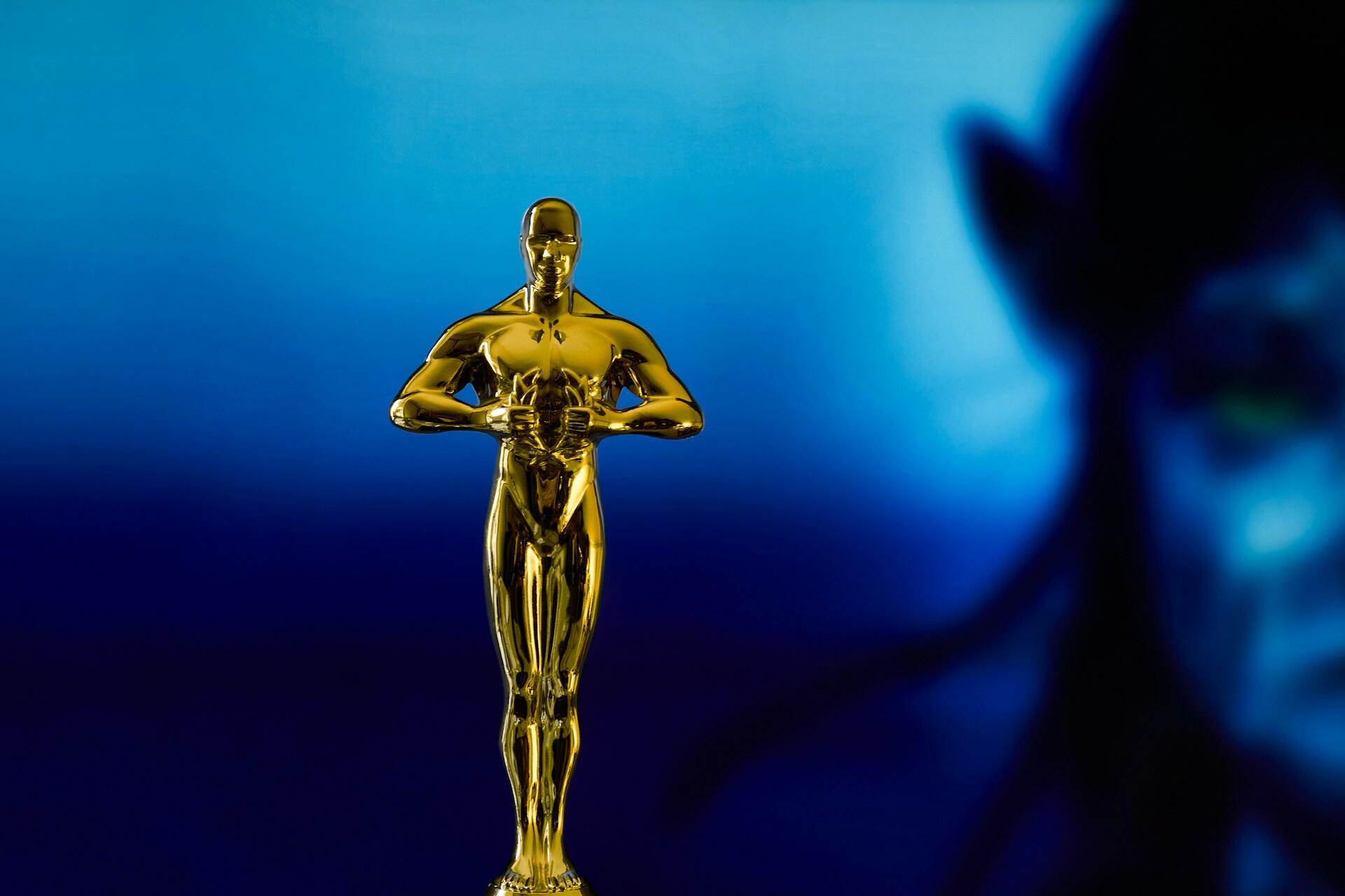 oscars statue in front of a blue background