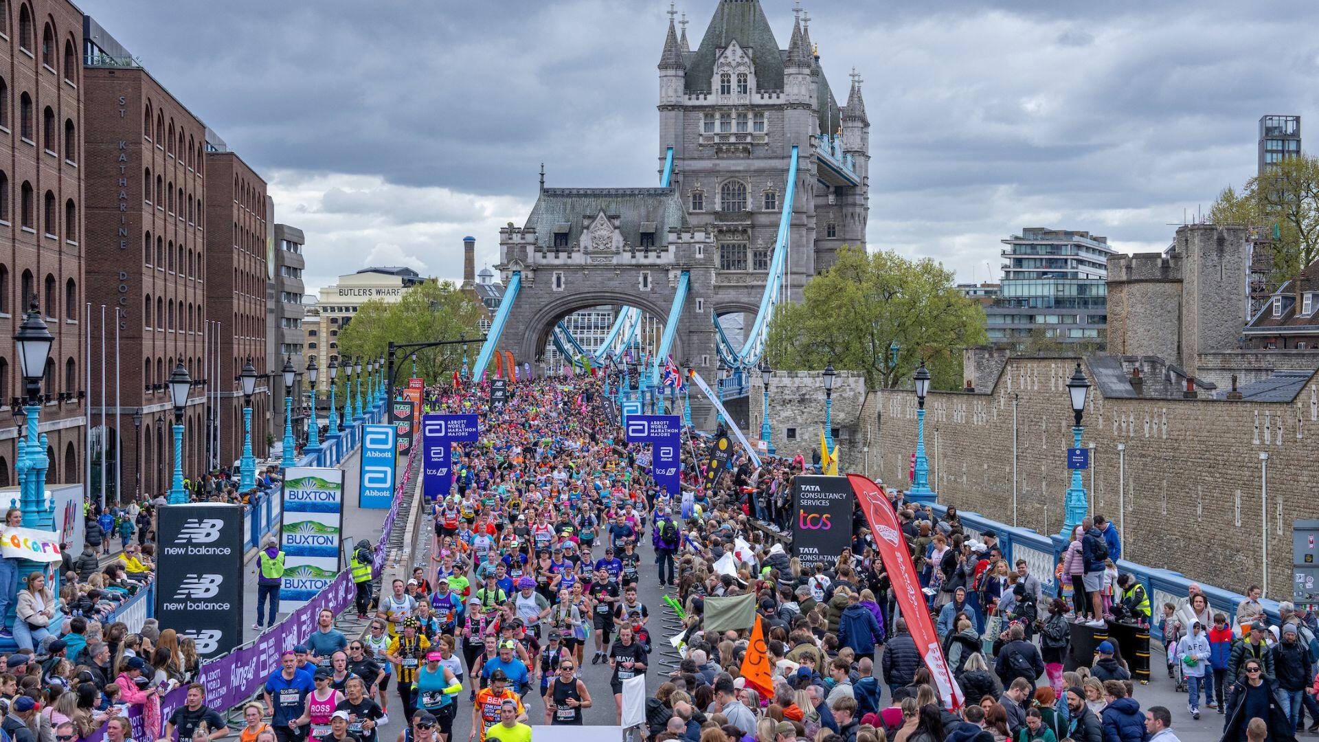 Marathon runners crossing Tower Bridge with spectators on the sides