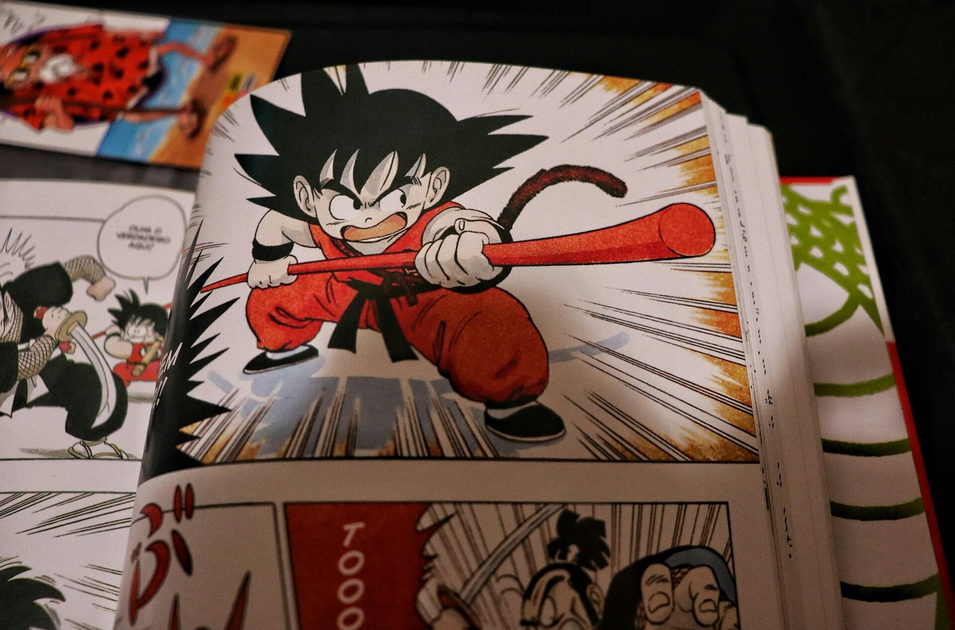 Close-up of a manga page featuring a character in red martial arts attire wielding a red staff in an action pose.