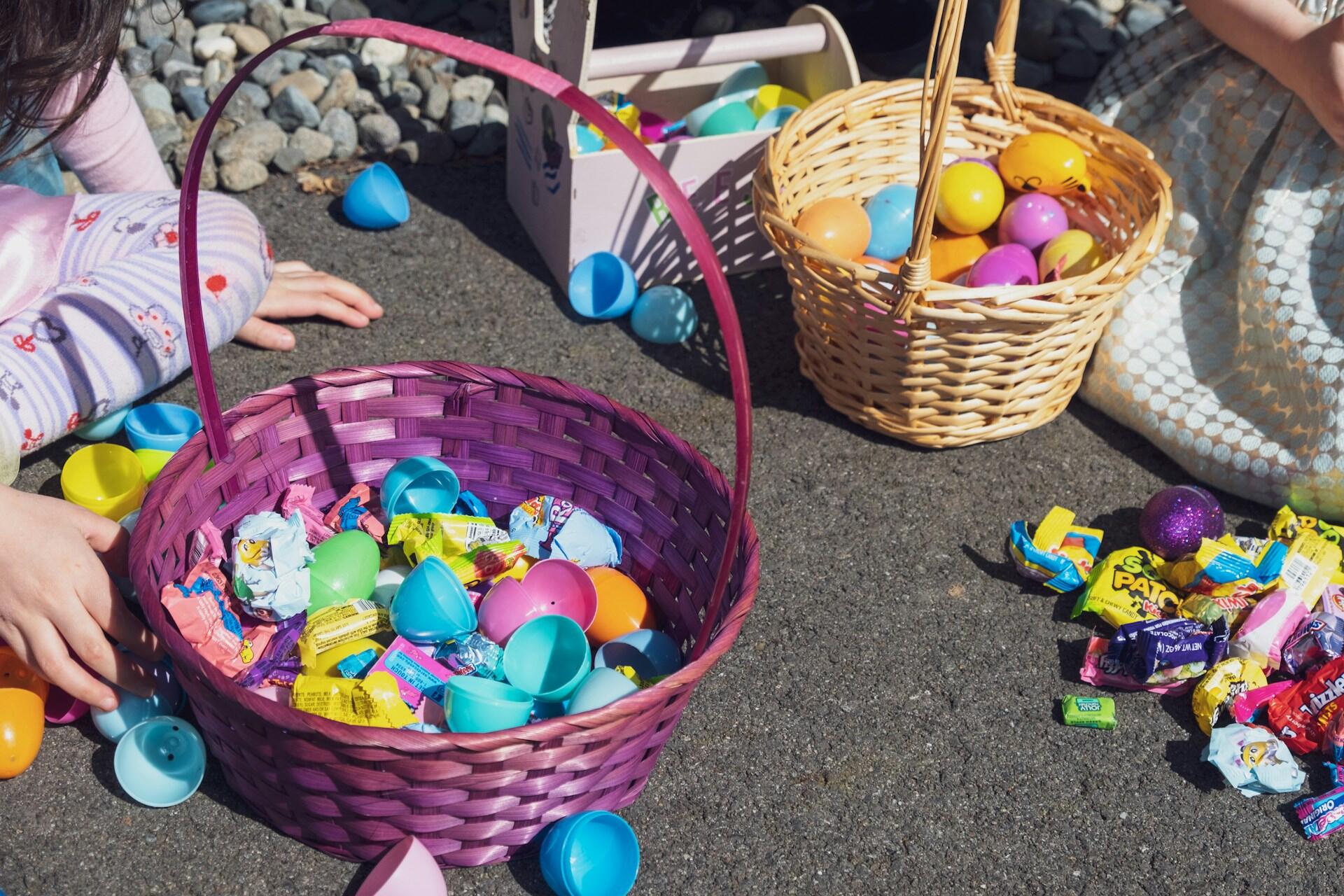 Children with Easter baskets filled with plastic eggs opened to reveal toys and candy inside.
