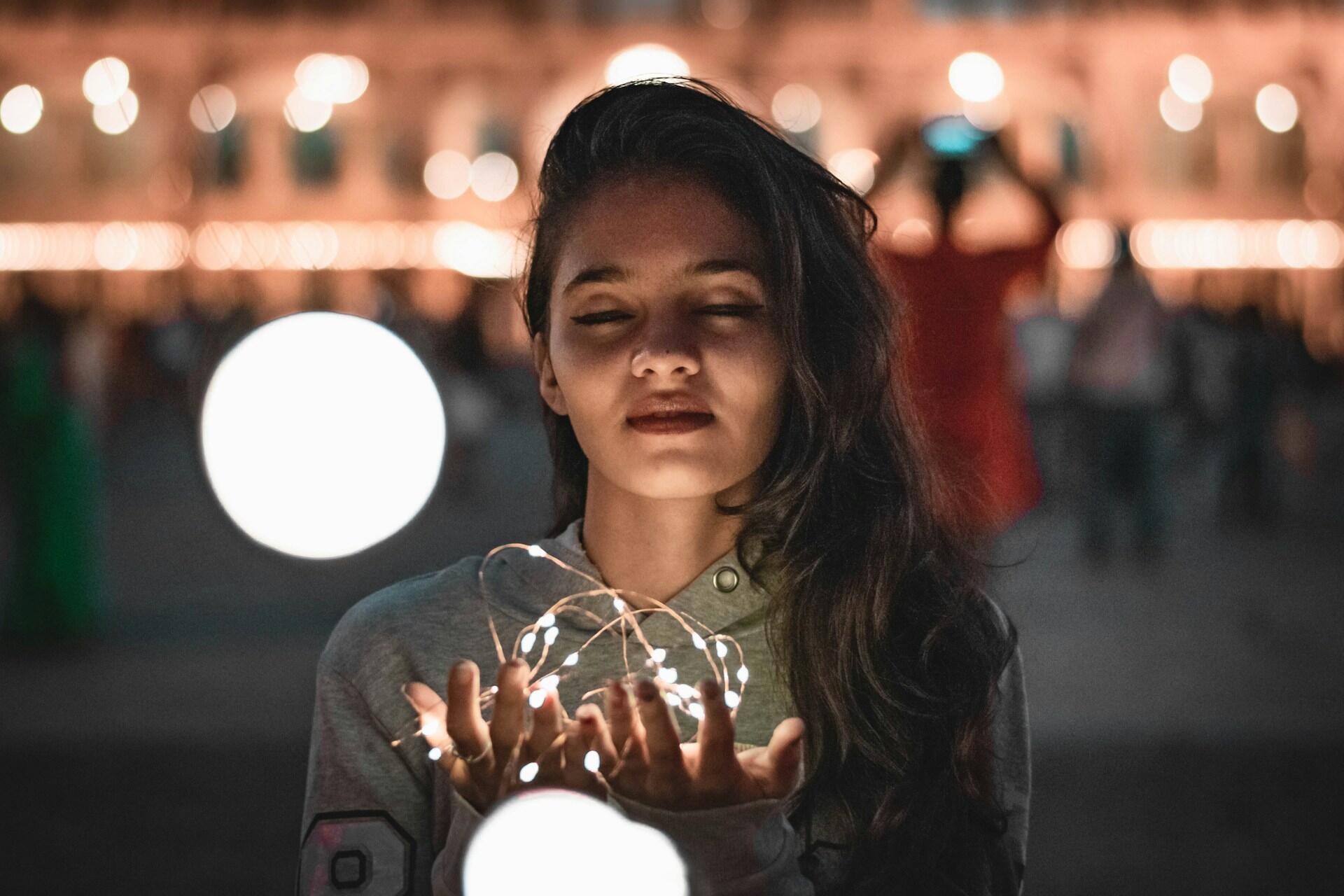 women holding fairy lights in a city centre