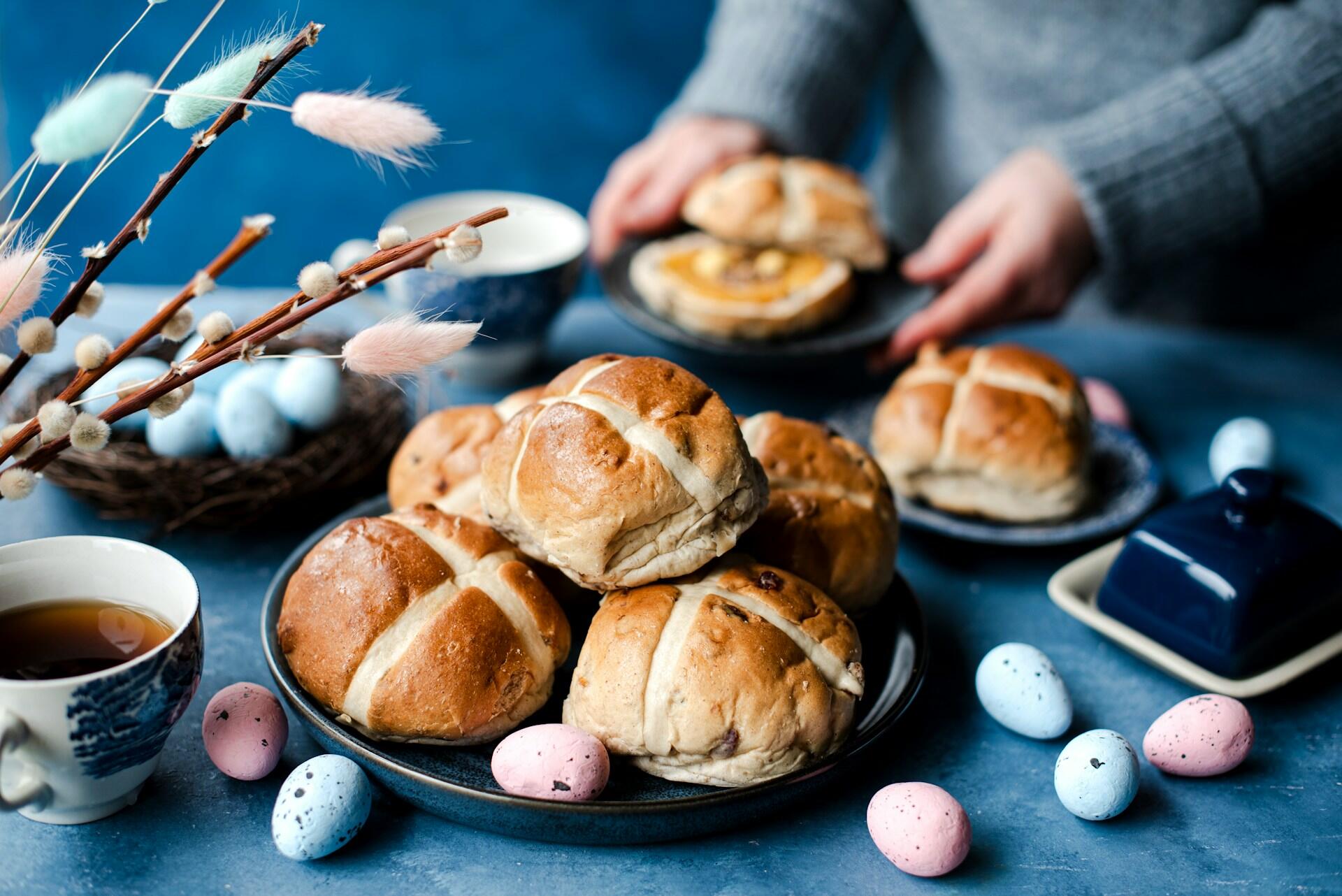 hot cross buns on a table with easter eggs