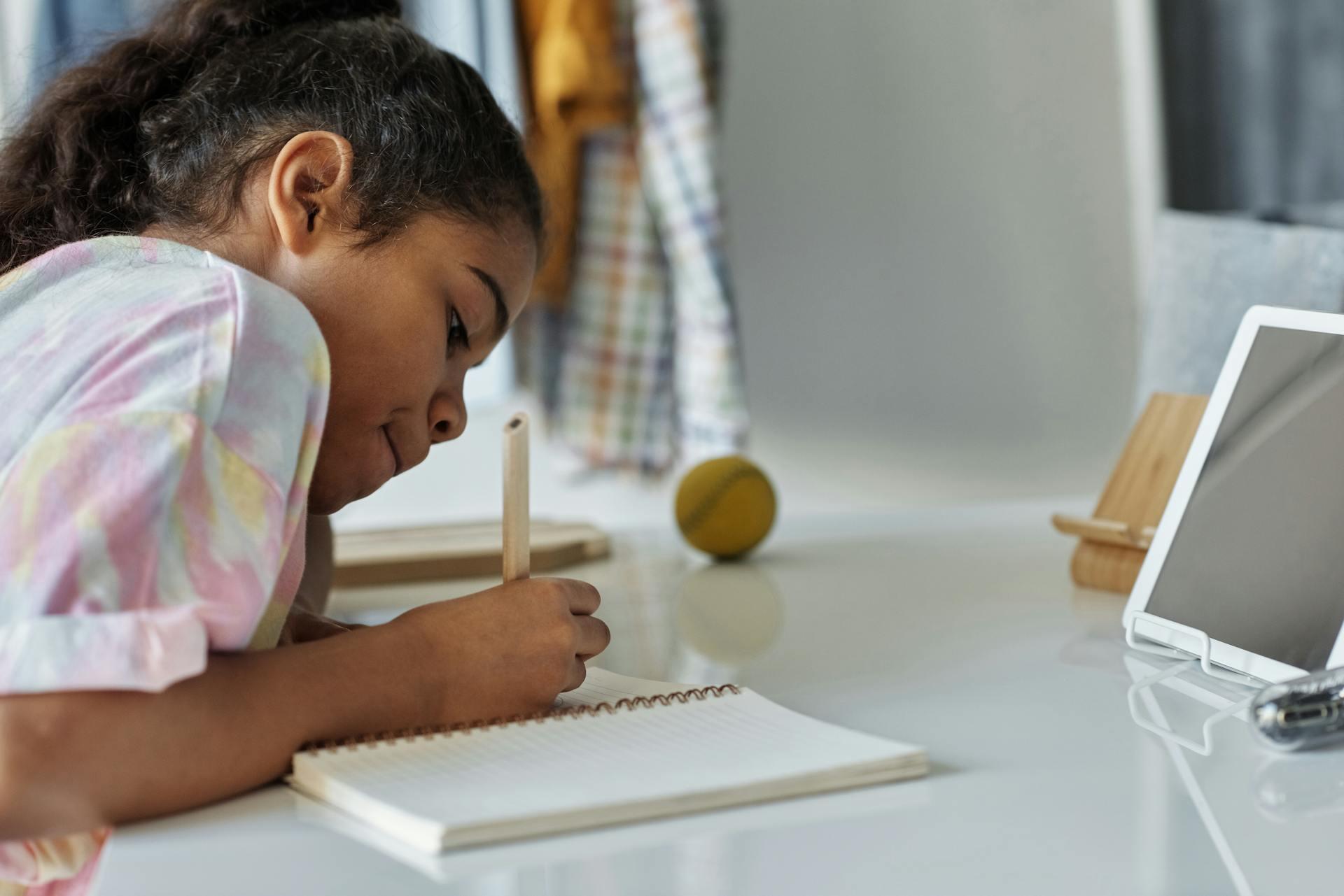 Image of girl writing in her notebook with pen