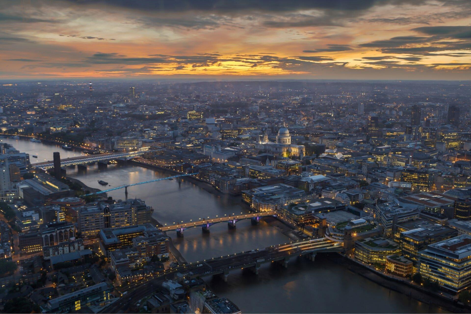 Aerial view of the London skyline at sunset with the River Thames and St Paul’s Cathedral visible.