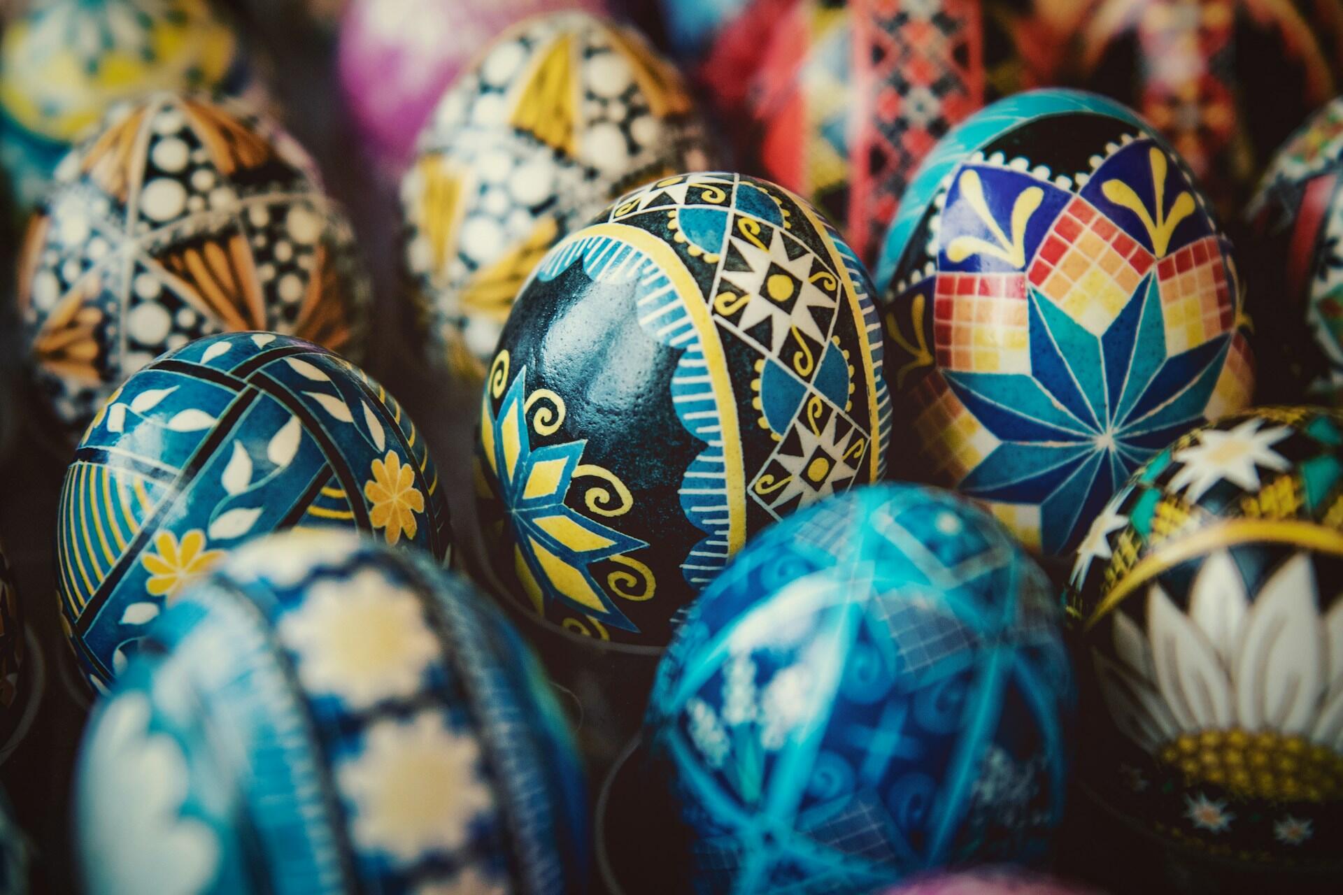Several intricately designed eggs featuring geographic patterns, flower motifs, and more with bright colours.