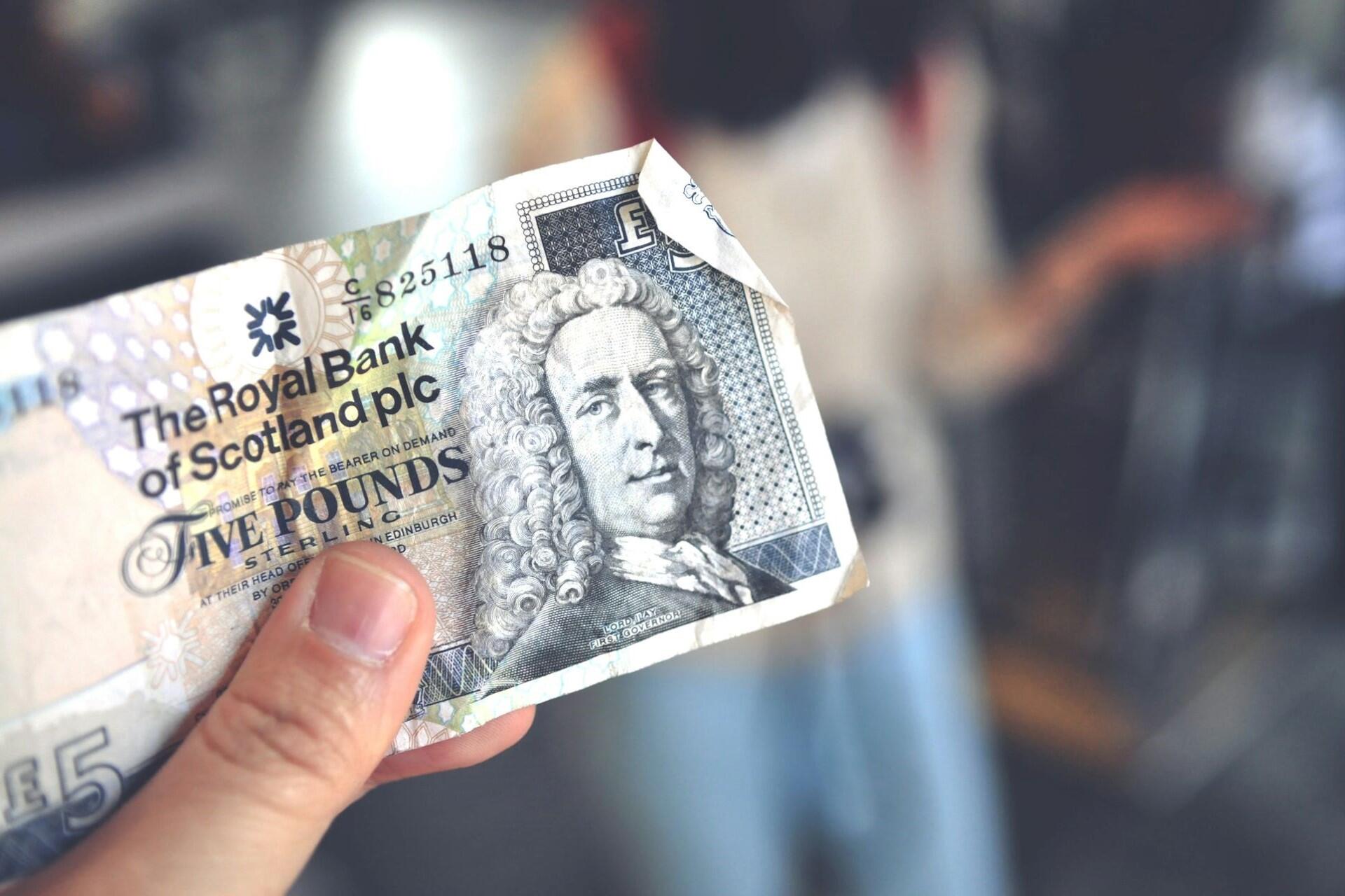 Scottish five pound banknote being held in hand