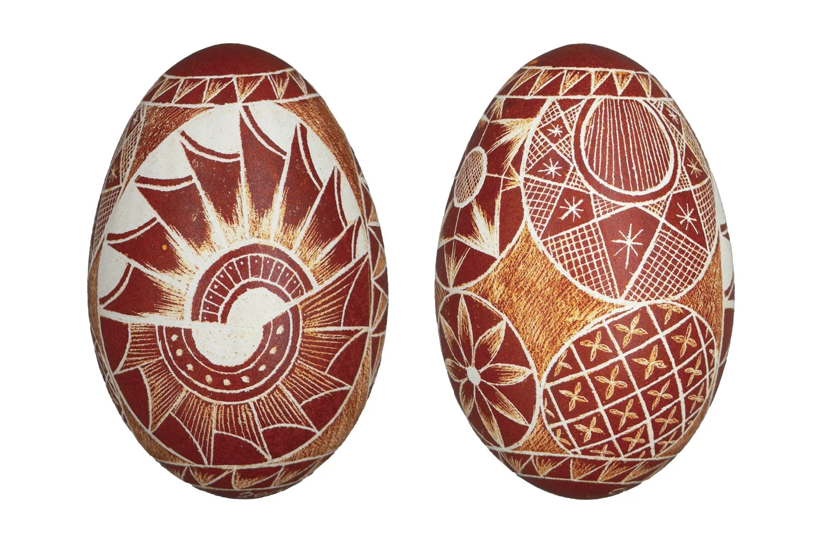 Two intricately decorated eggs featuring traditional red and white patterns, showcasing geometric and floral designs.
