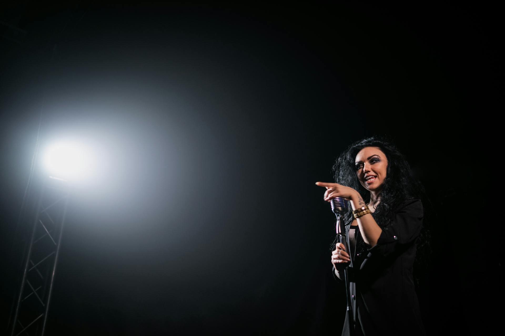 Image of a woman on stage singing into a mic