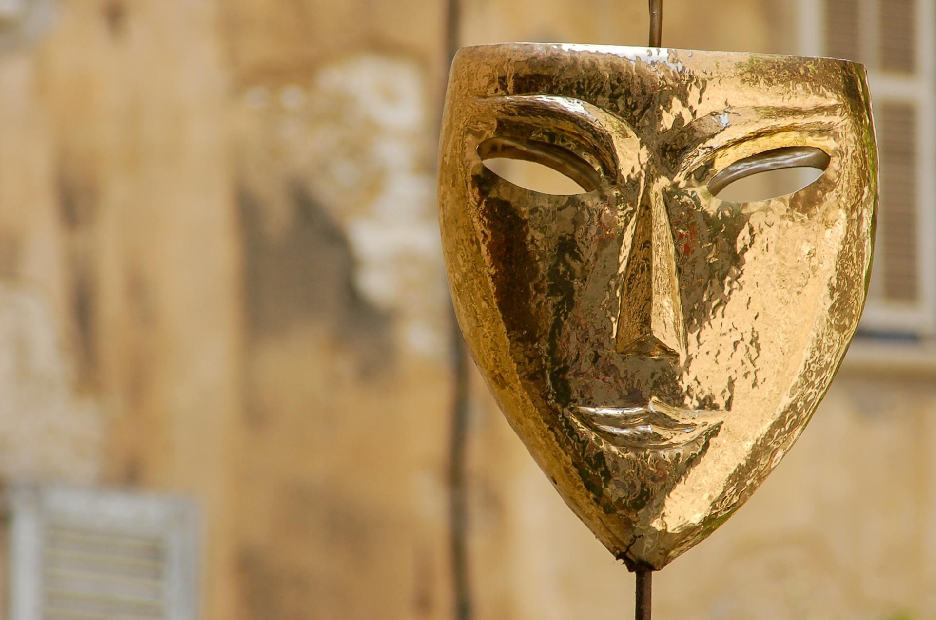 Image of a golden theatre mask with bokeh in background 