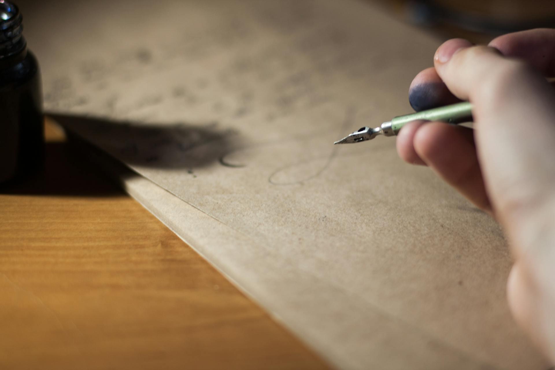 Image of an ink pen hovering over a written manuscript