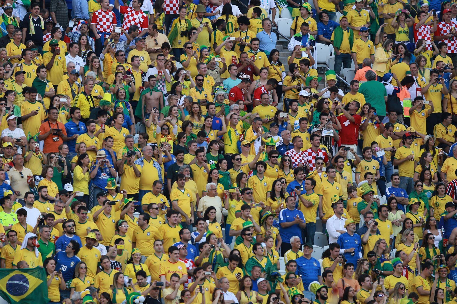 Brazil supporters wearing yellow shirts cheering during a FIFA World Cup match.