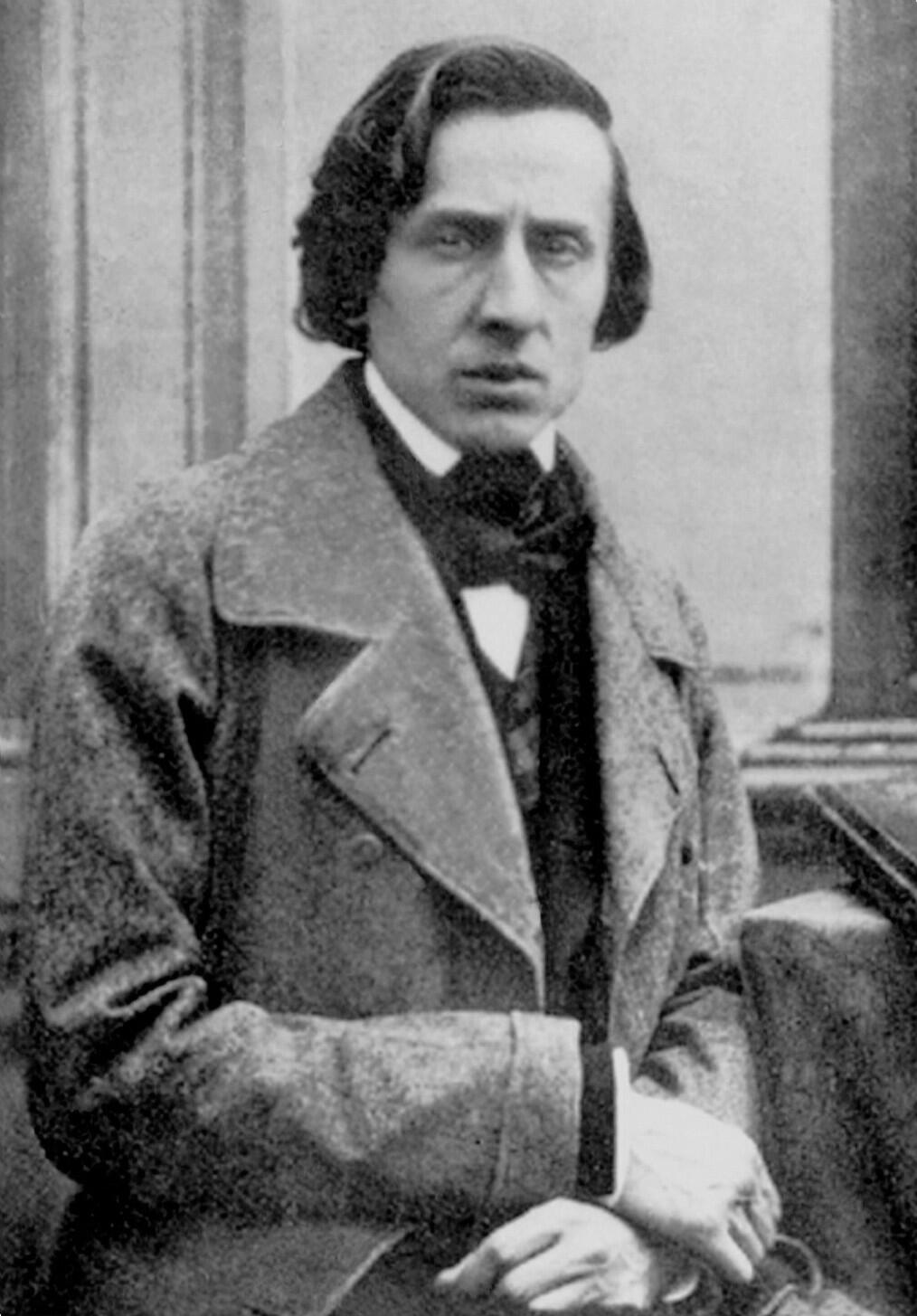 Black and white portrait photograph of Frédéric Chopin looking intently forward, wearing a dark coat and cravat.
