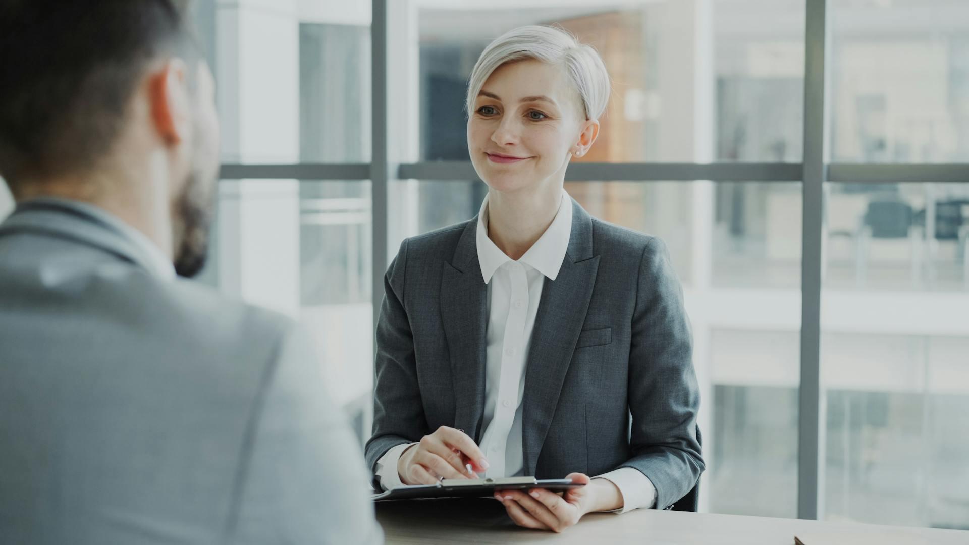 Woman with dyed white hair interviewing a man