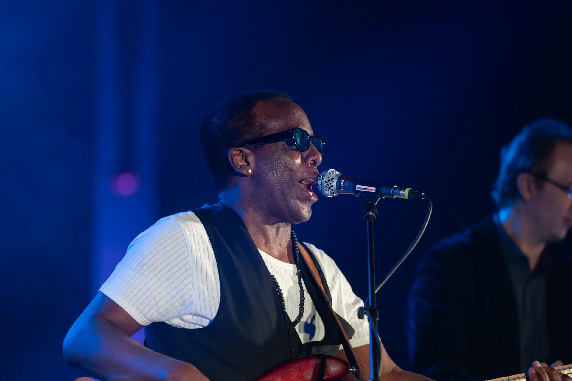 Singer performing on stage with microphone after preparing with vocal warm-up exercises.