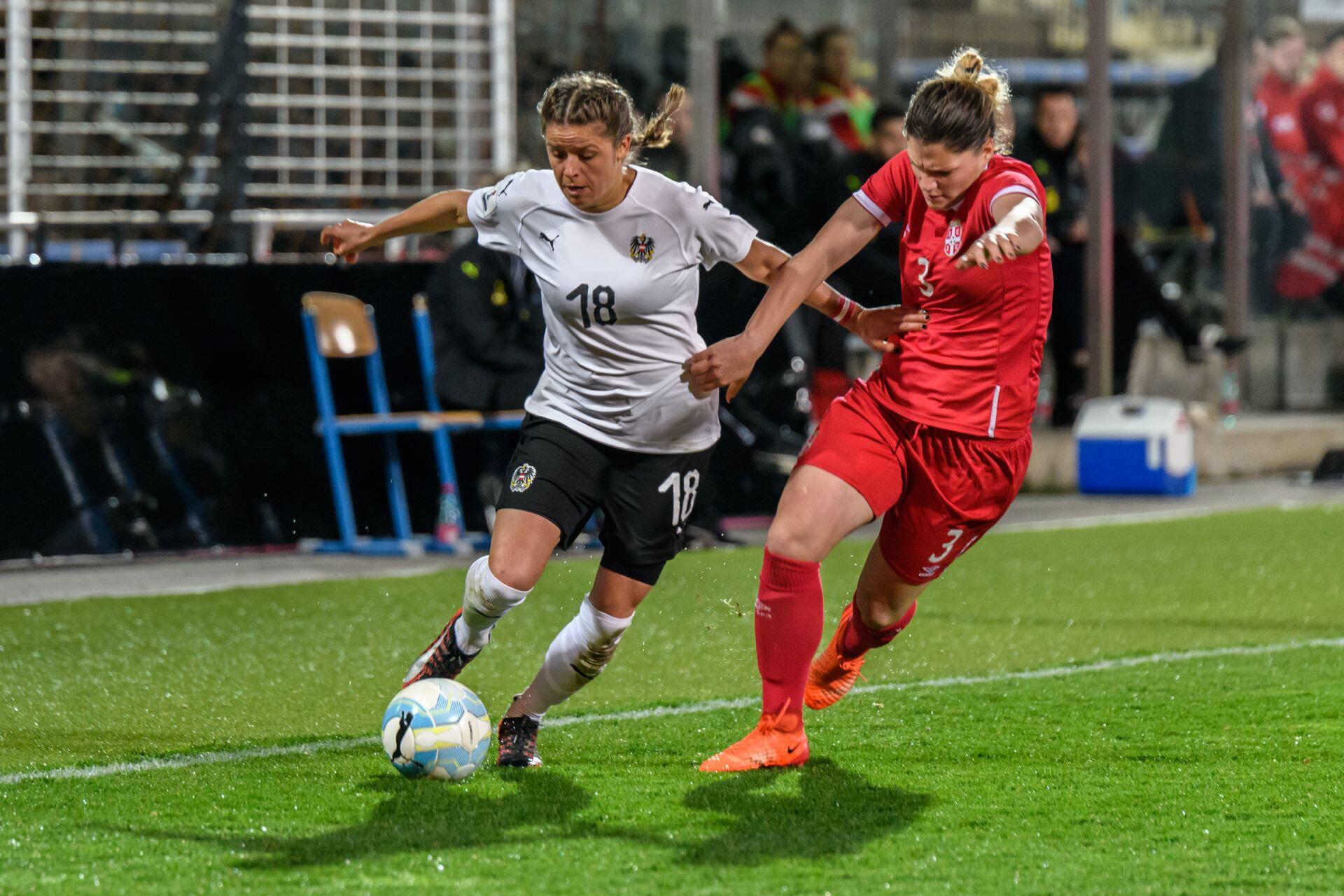 Austria and Serbia players competing for the ball during a women’s international football match.
