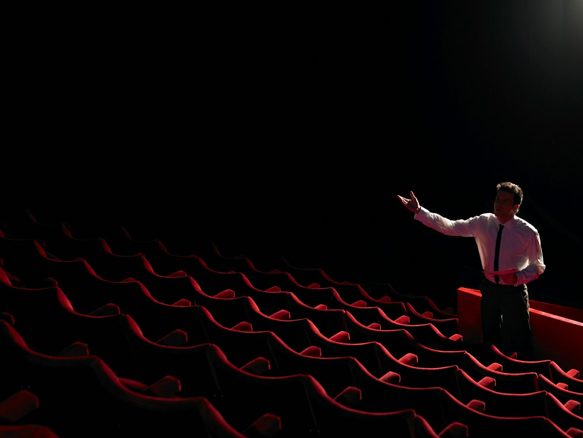 actor practicing giving lines in front of empty theatre seats