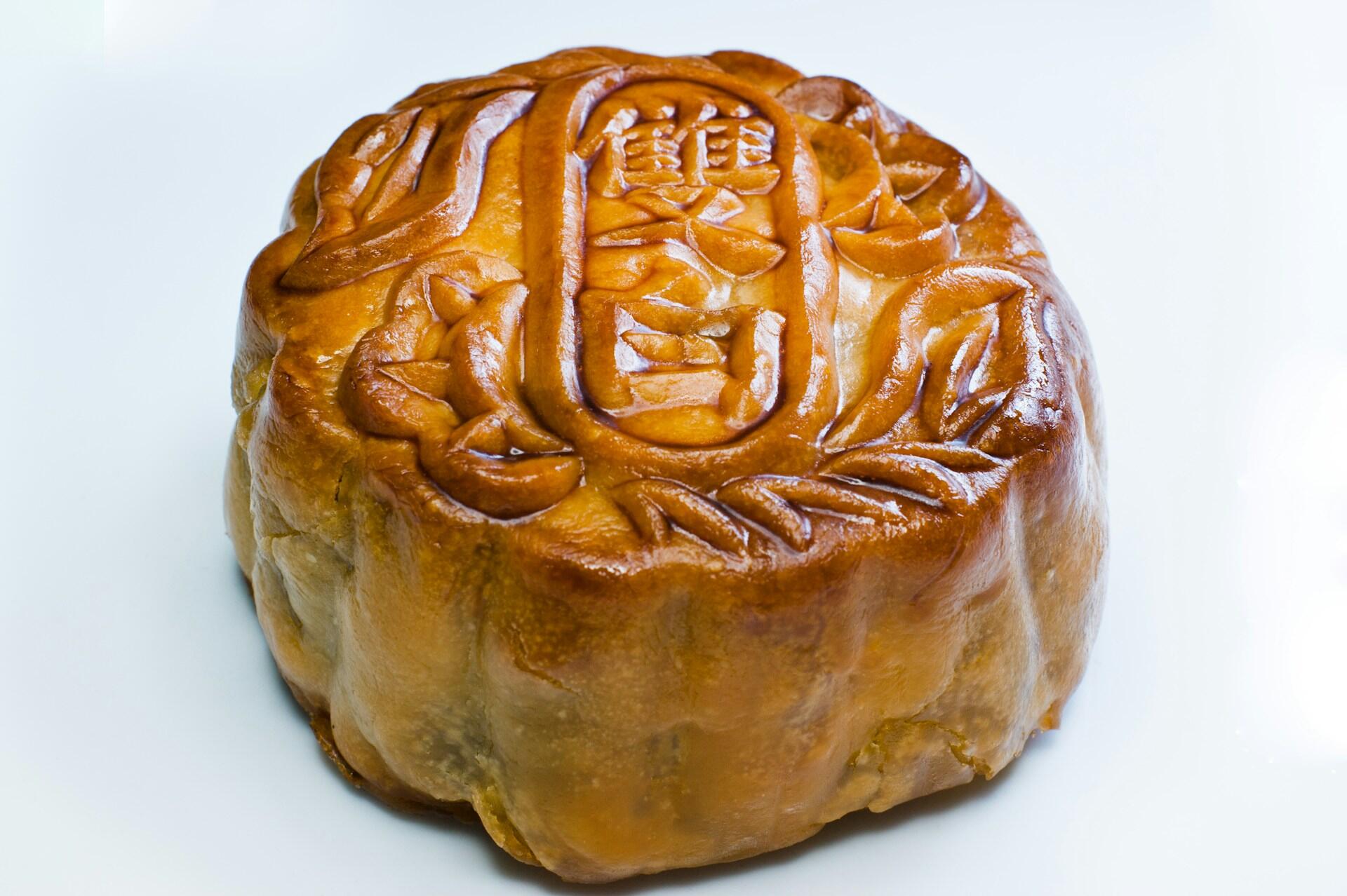 A Chinese mooncake featuring Chinese writing on a plain white surface.