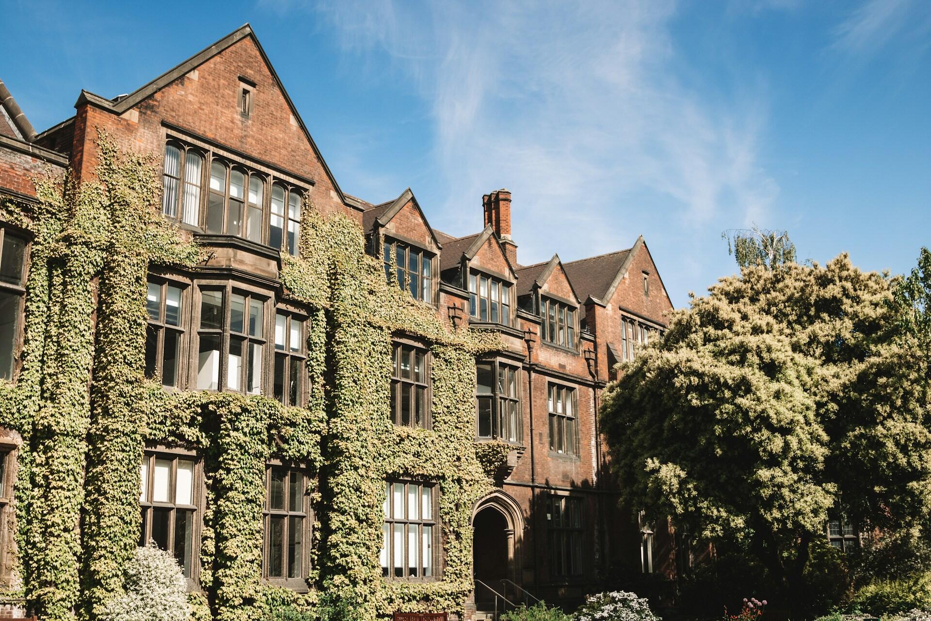 Ivy-covered brick university building under a blue sky