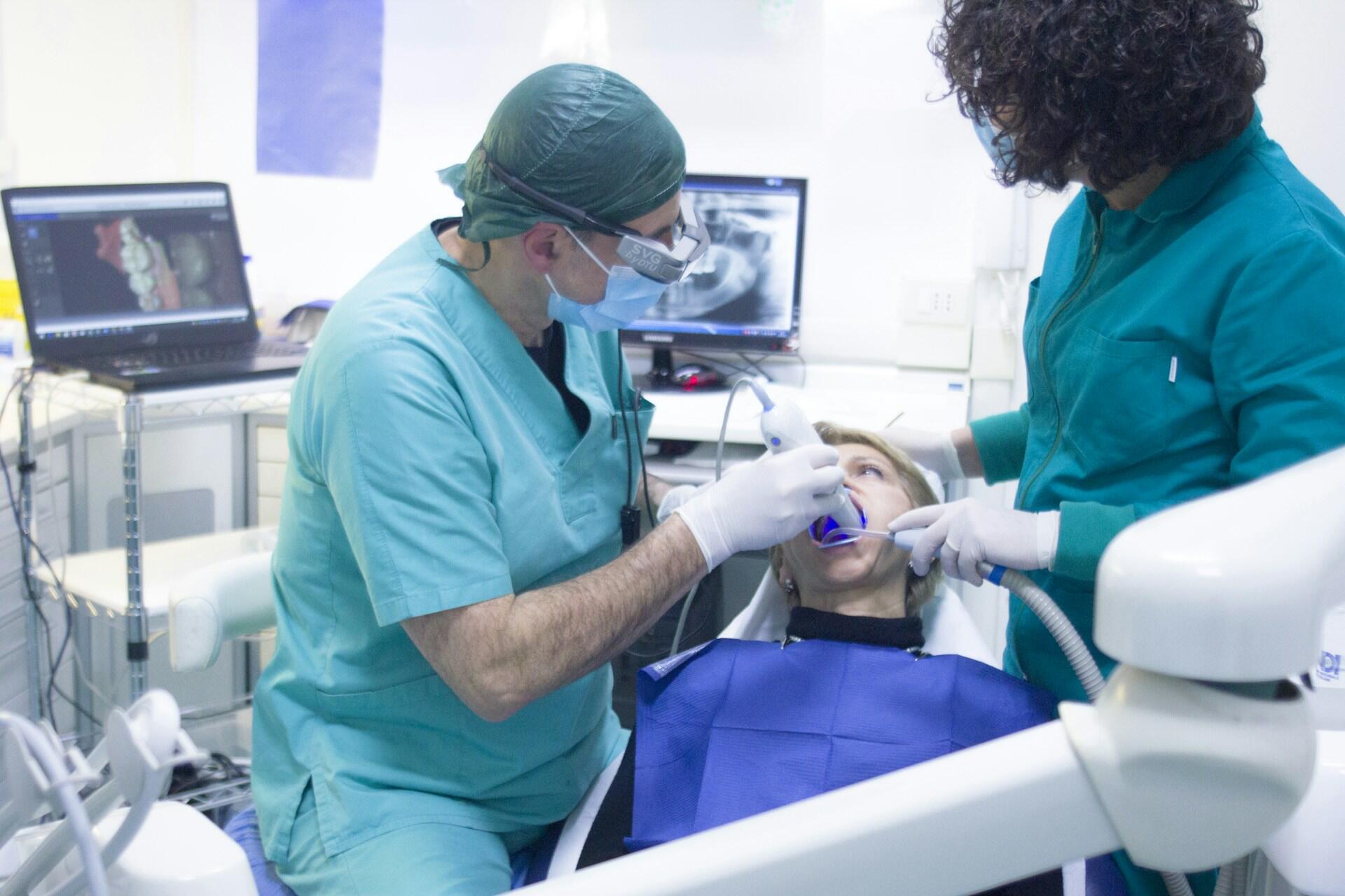 Dentist and assistant treating a patient in a dental chair