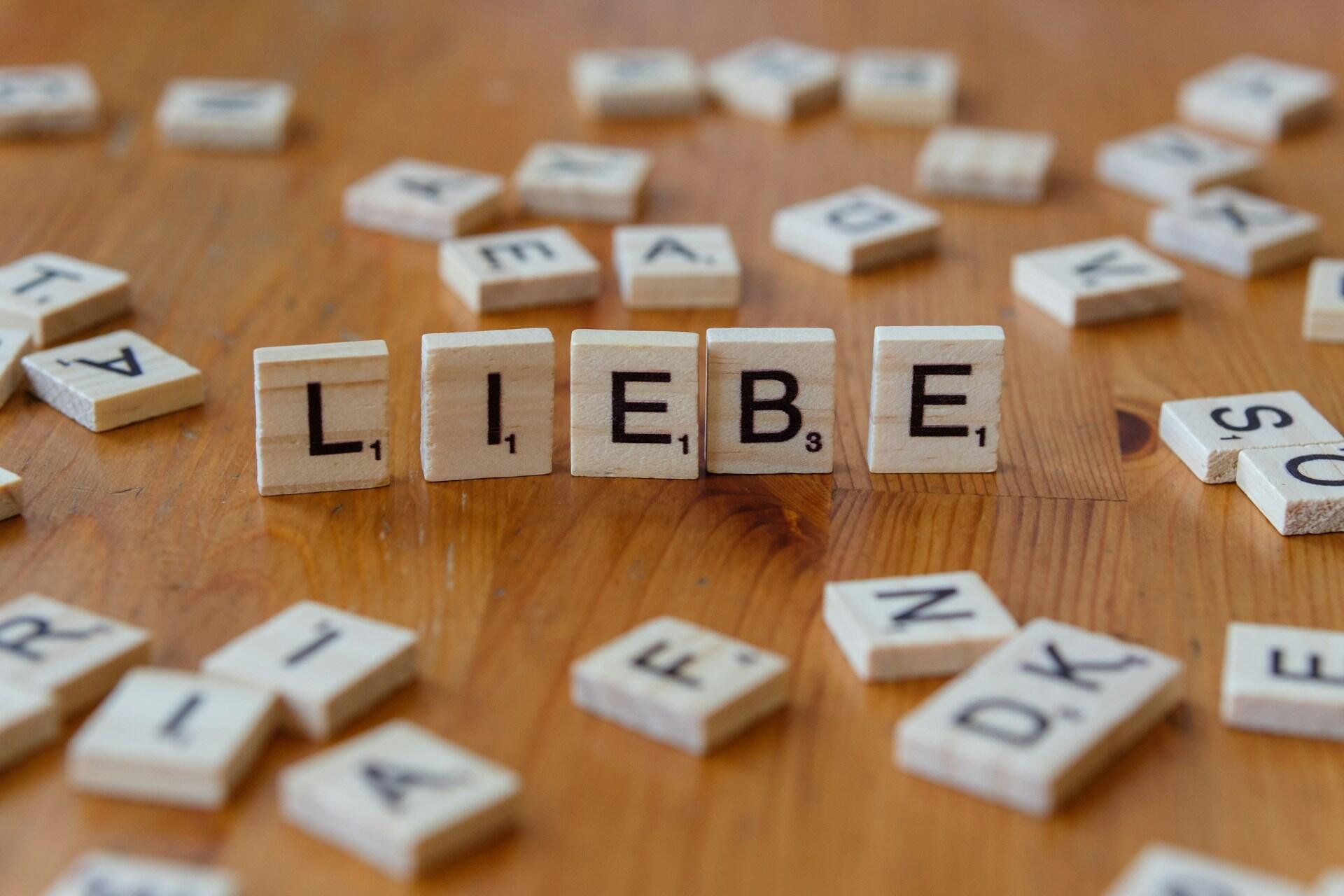 Wooden letter tiles spelling LIEBE on a wooden table.