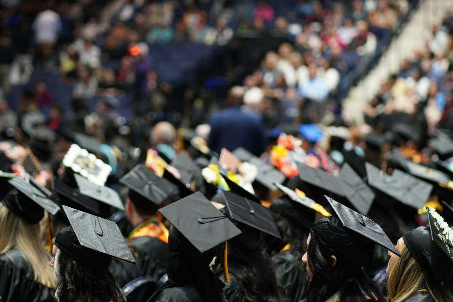Graduates wearing black mortarboards at a graduation ceremony