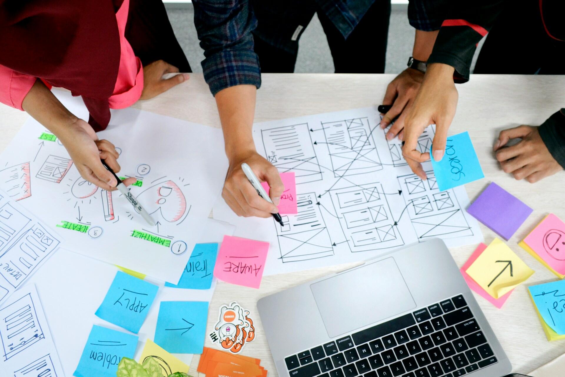 Marketing designers planning website wireframes and campaign layouts at a desk