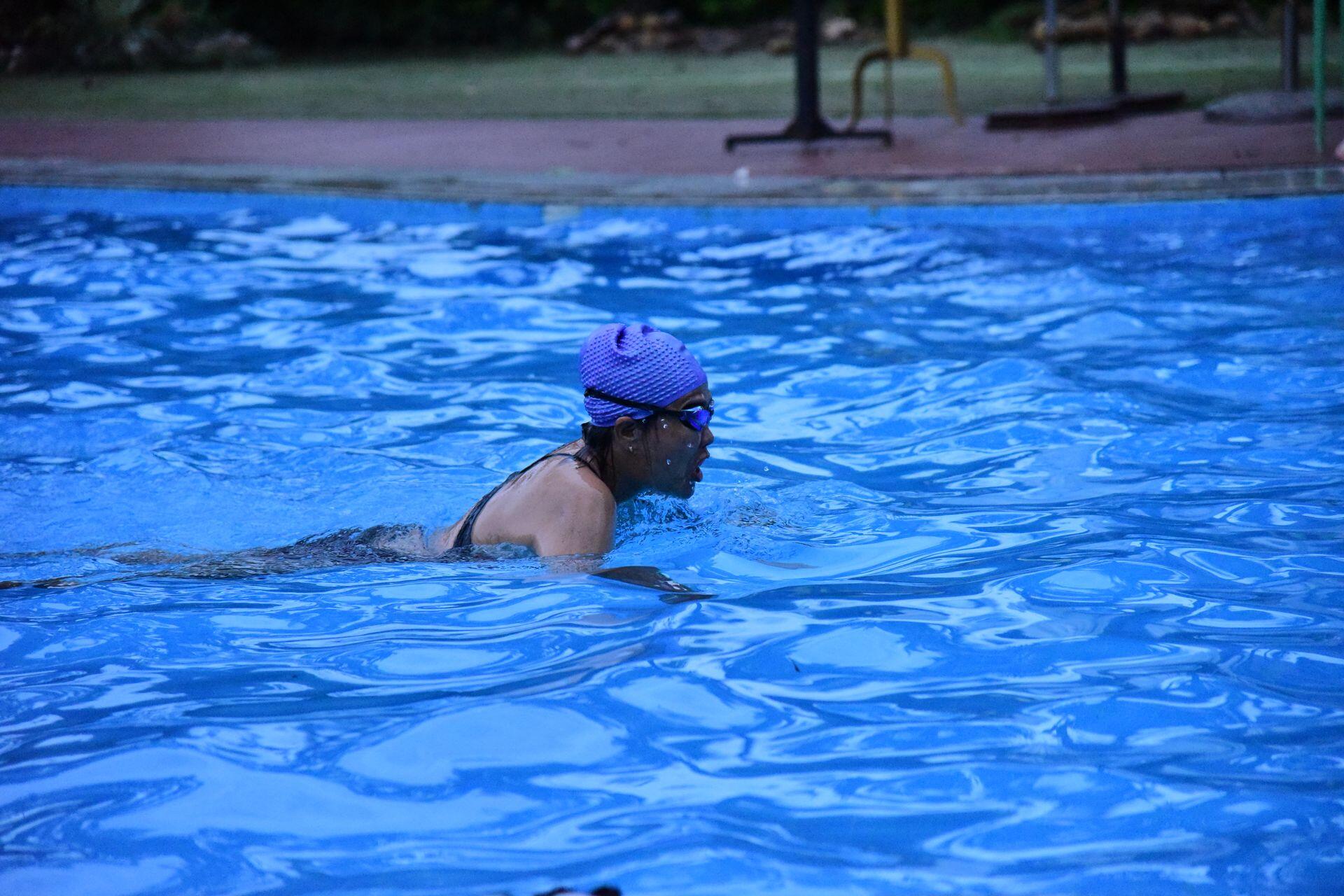 Person swimming in pool during early evening
