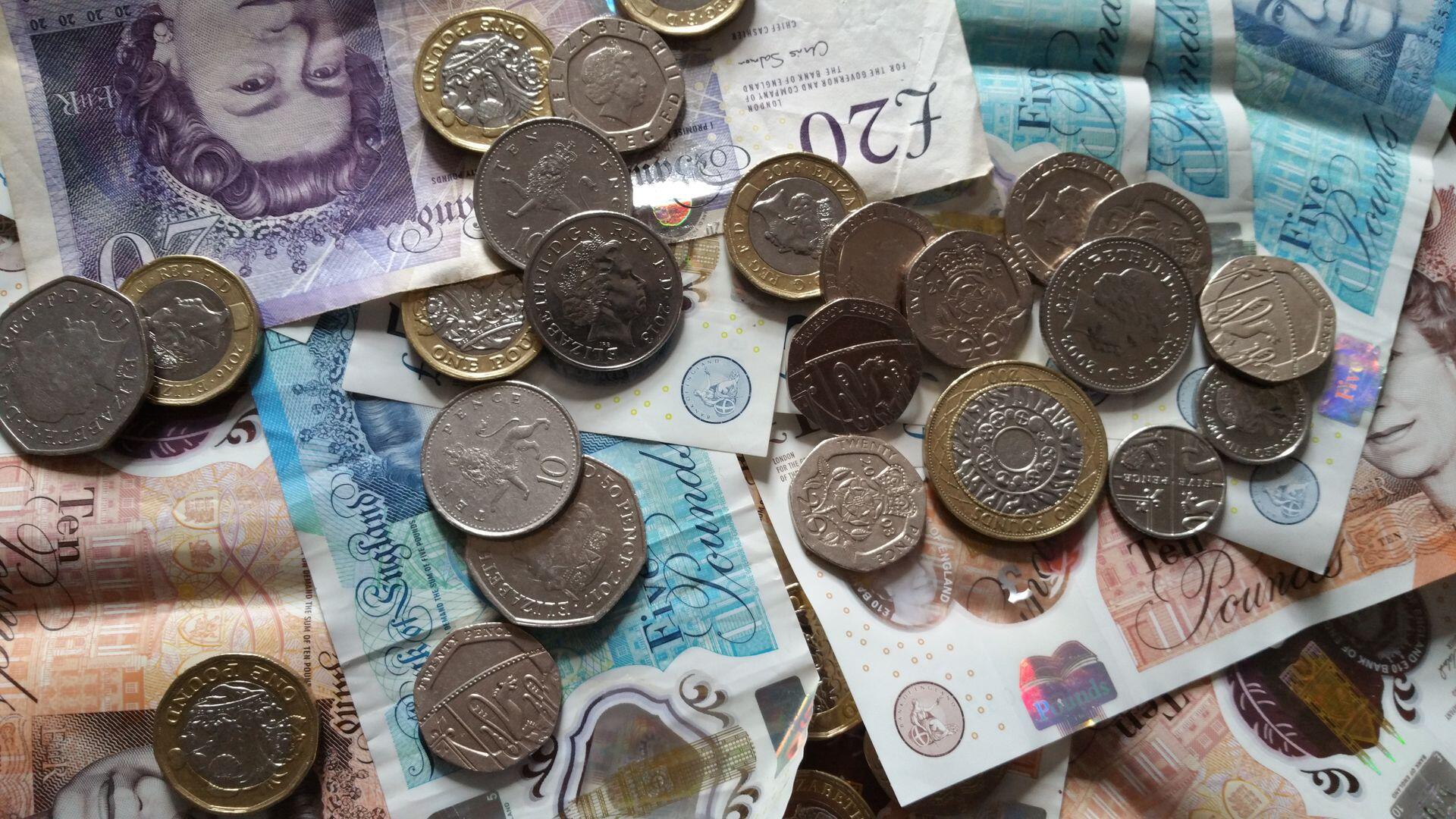 Image of pound coins and notes stacked on one another