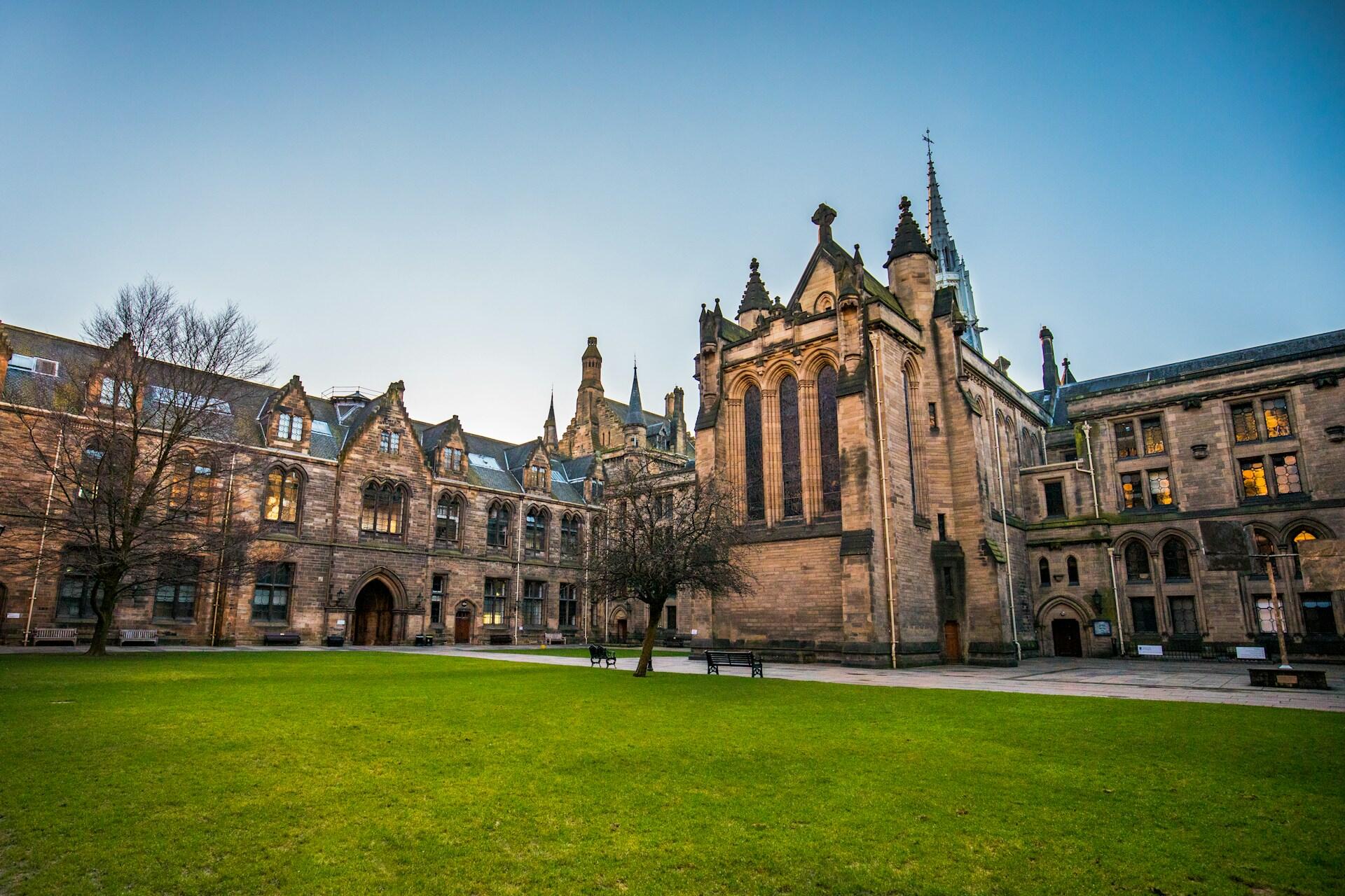 Historic university buildings around a green lawn