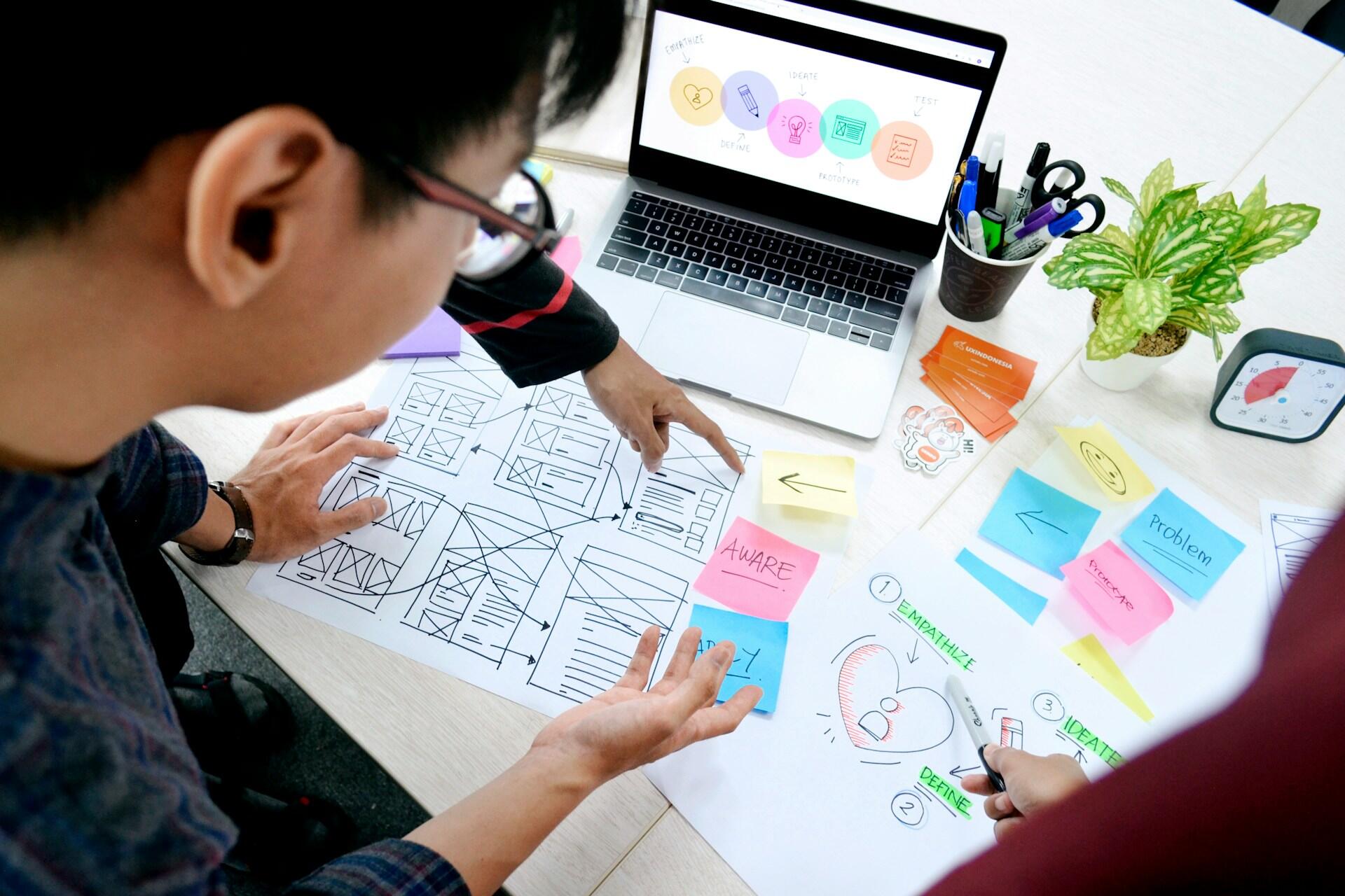 Designers planning a user journey with wireframes and sticky notes