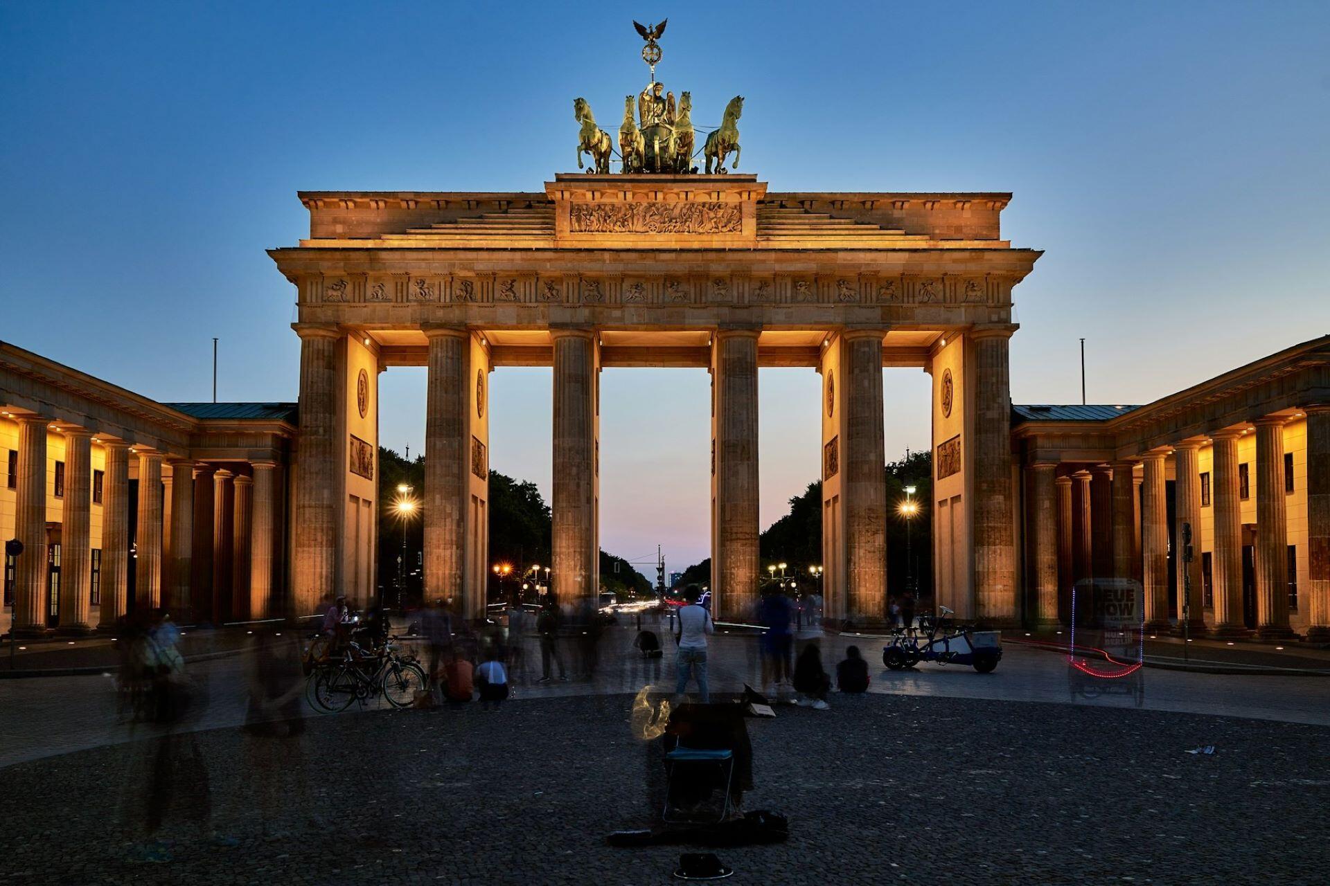 Brandenburg Gate at dusk with people in the square