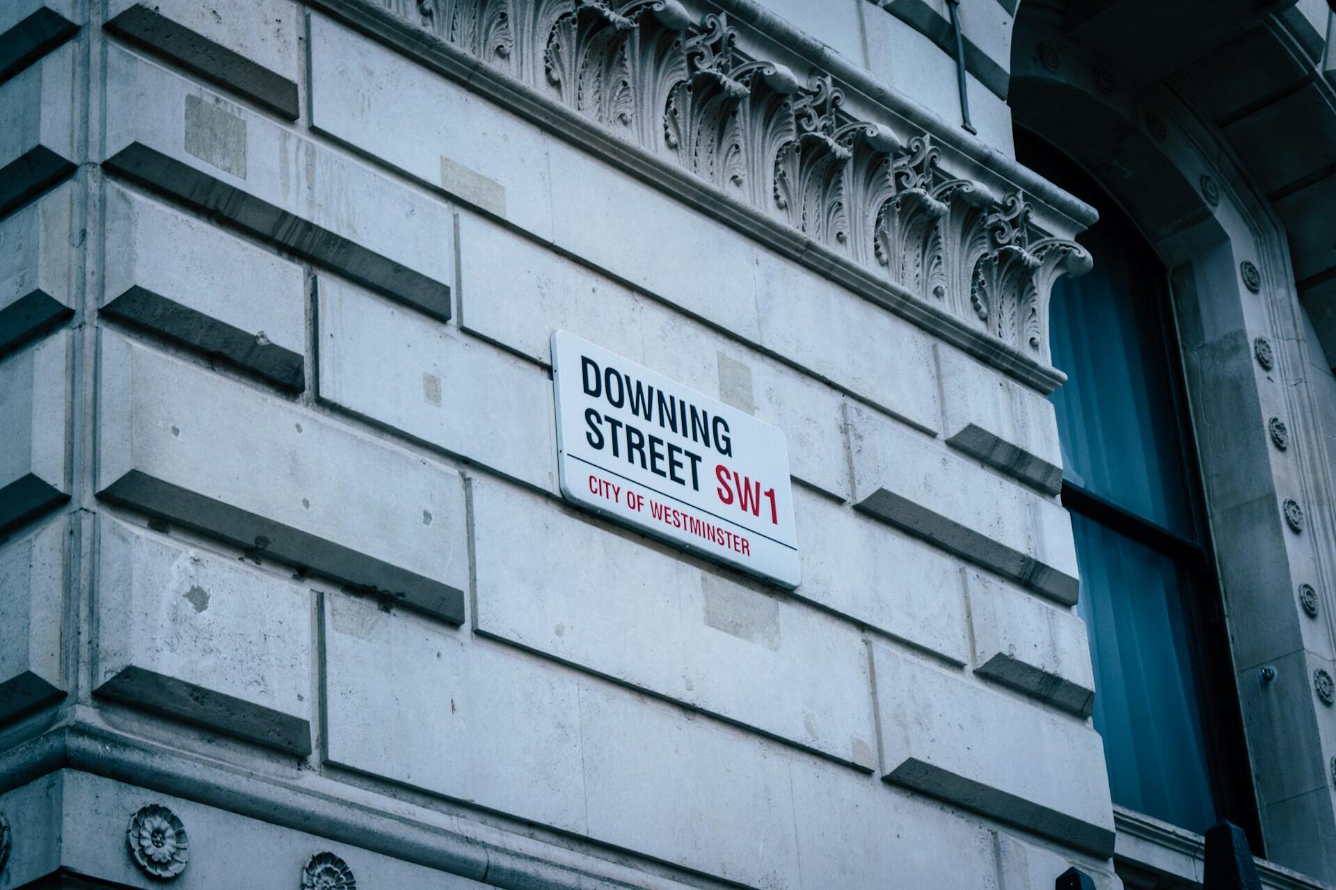 Downing Street SW1 City of Westminster street sign on a stone building.
