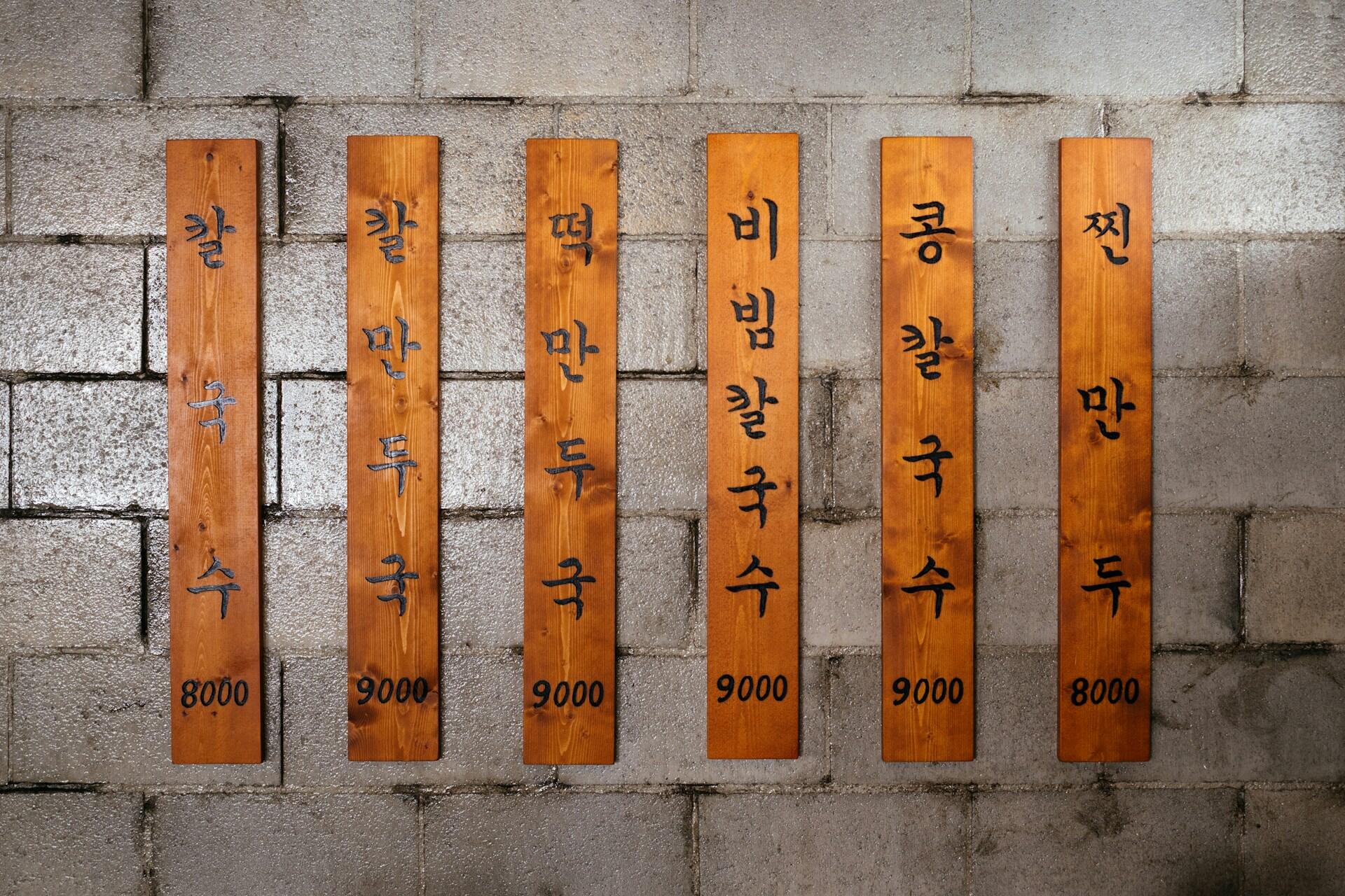 Six flat bamboo sticks with Korean writing on them.