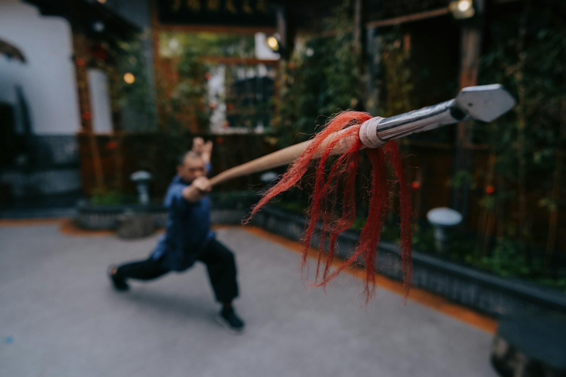 a man swinging a Chinese staff.