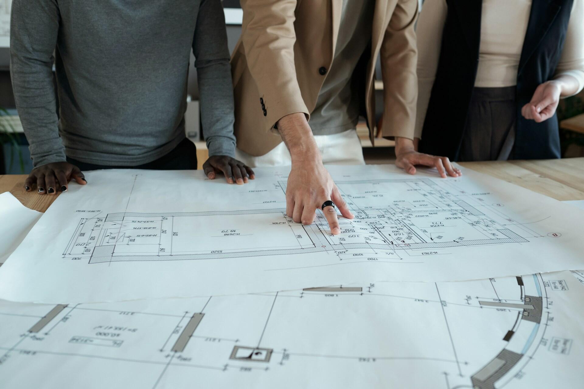 event production team looking at CAD drawings of a venue in a planning meeting