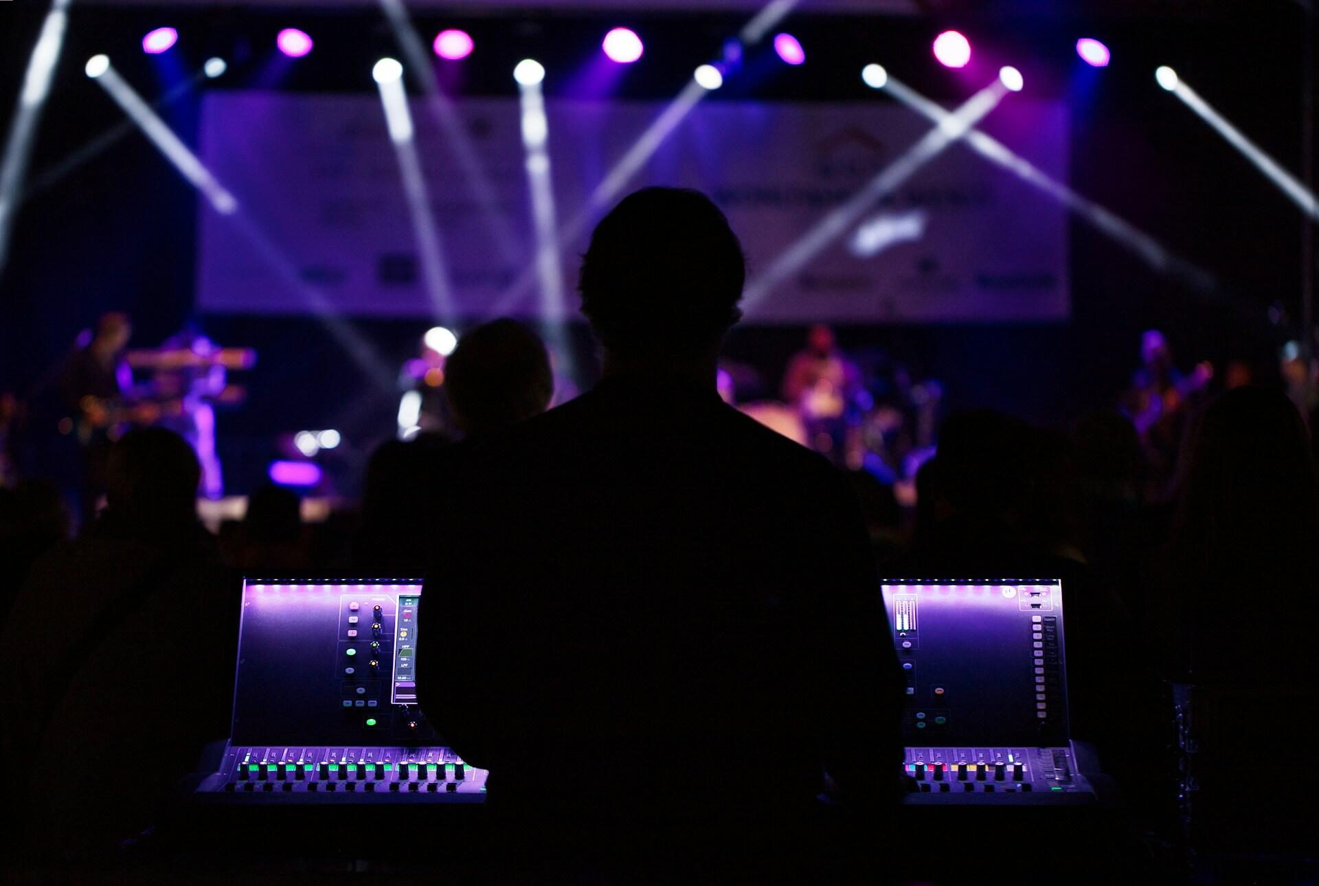 lighting or audio technician monitoring live event and adjusting equipment in real time