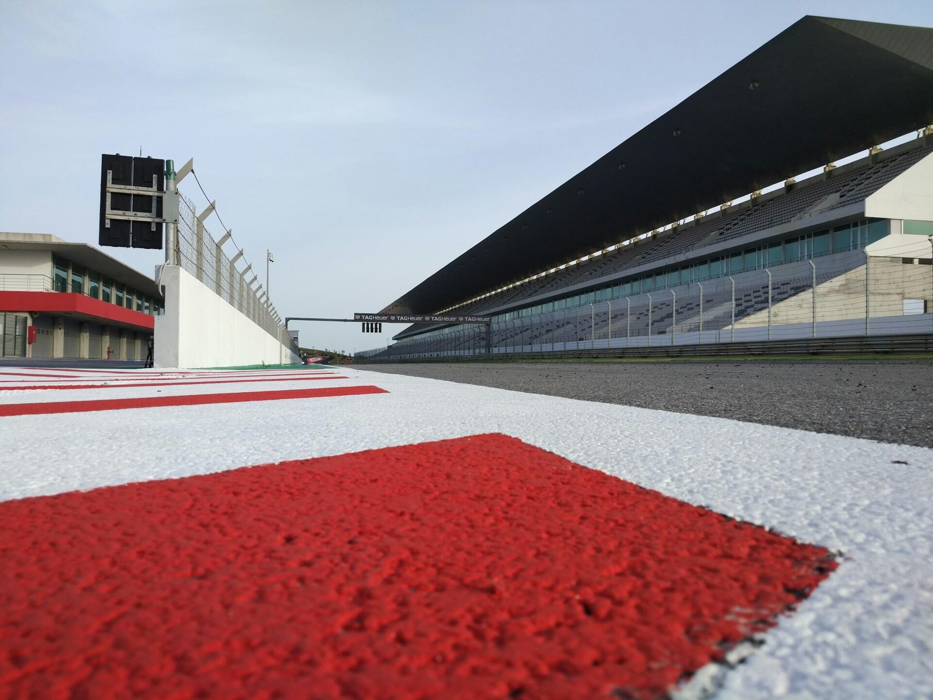 A view of the Ferrari F1 team's track, showcasing the racing circuit and surrounding facilities under clear blue skies.
