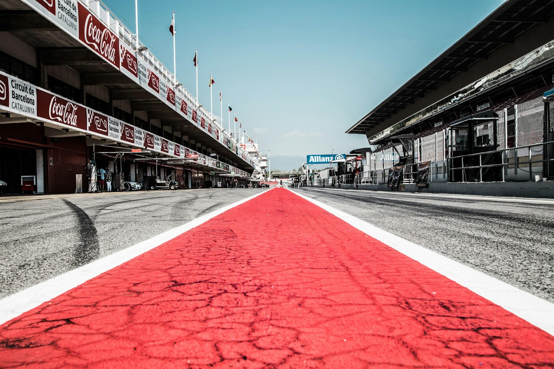 A red athletic track featuring a prominent white lane line running along its length.