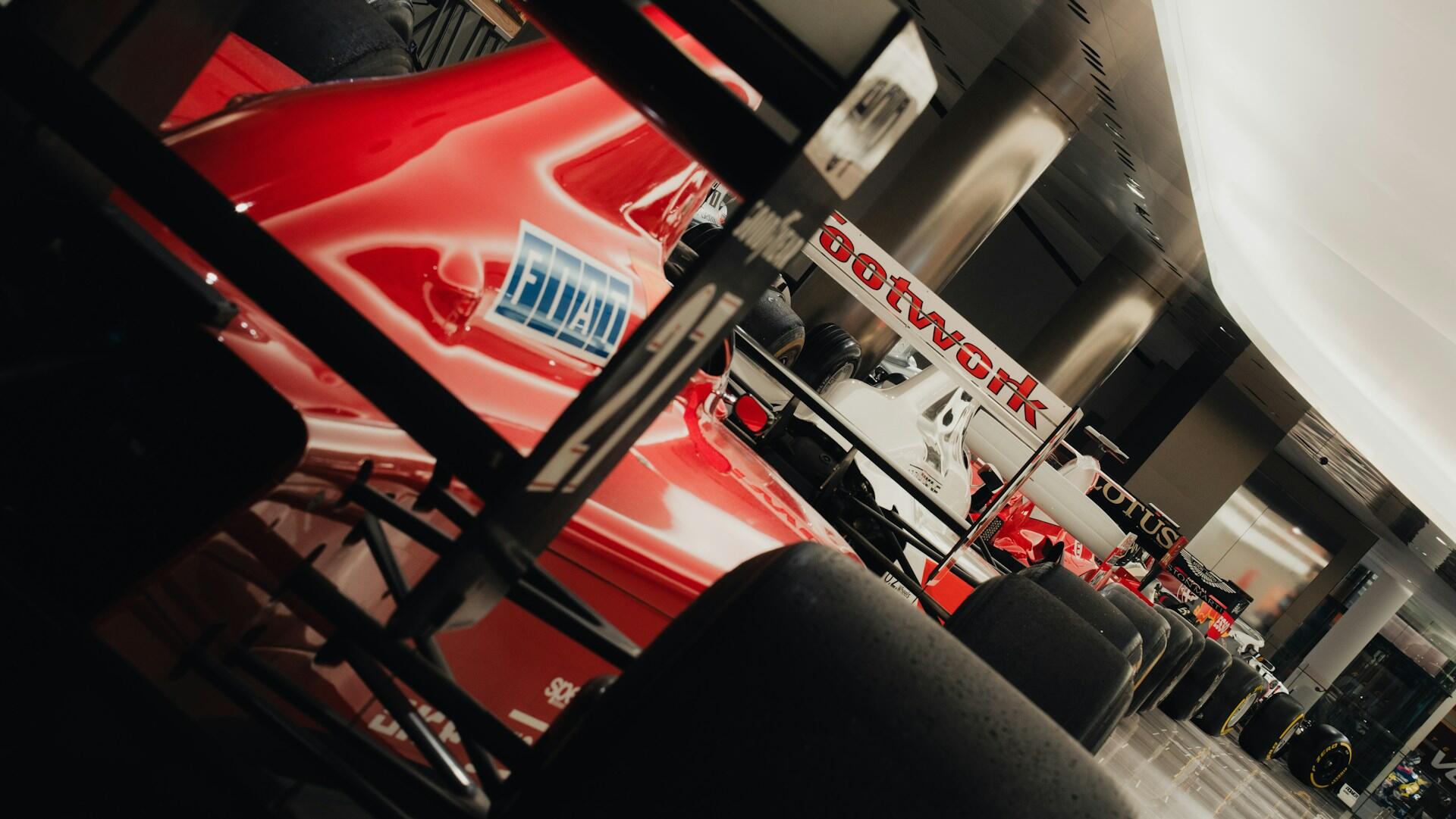 A red racing car parked inside a spacious garage, showcasing its sleek design and polished exterior.